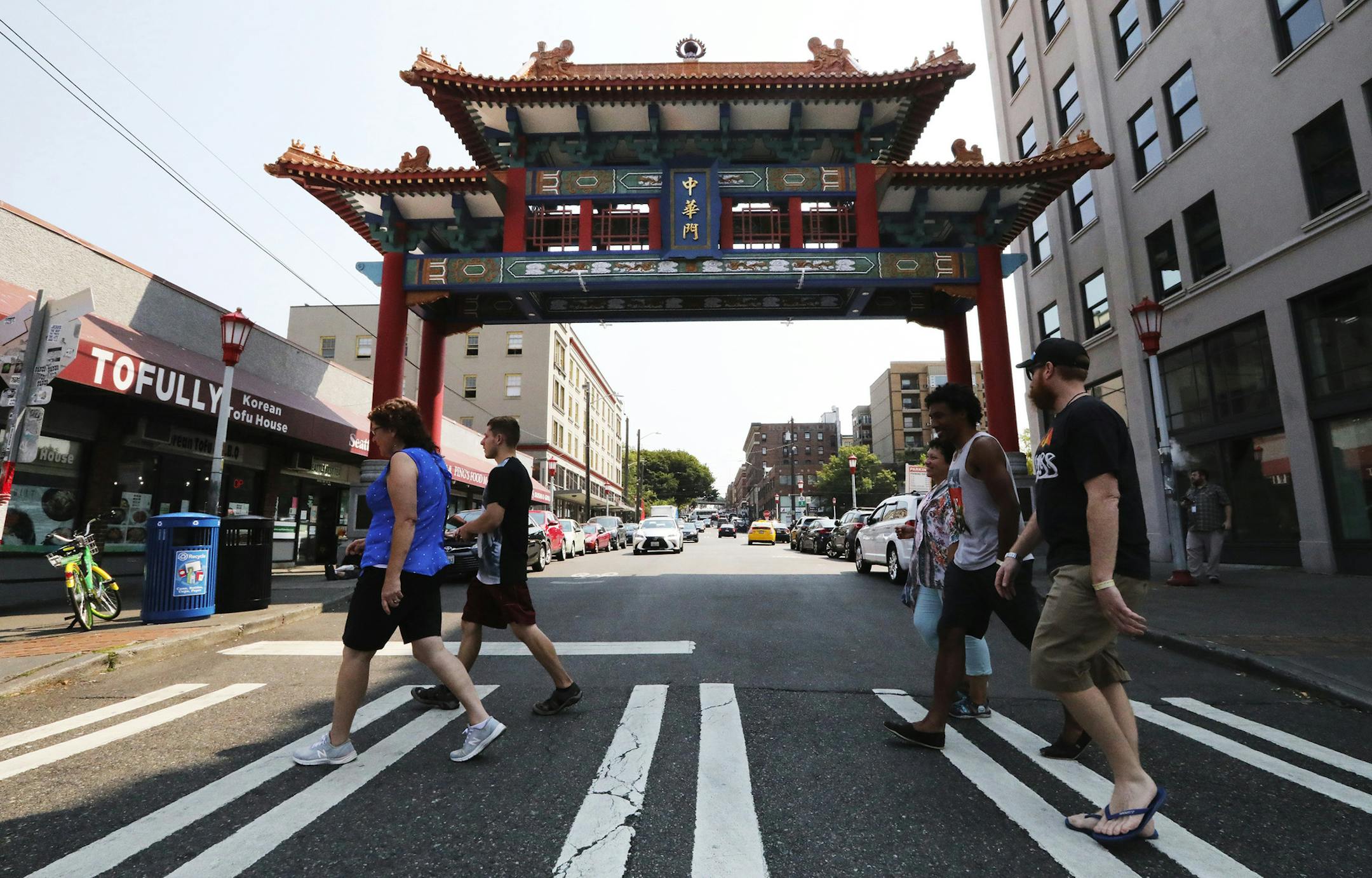 The tour group heads past the Chinese Gate on King Street dedicated a decade ago. King Street is considered the business heart of Chinatown International District (says Don Wong) and the gate a welcoming symbol. (Alan Berner/The Seattle Times/TNS)