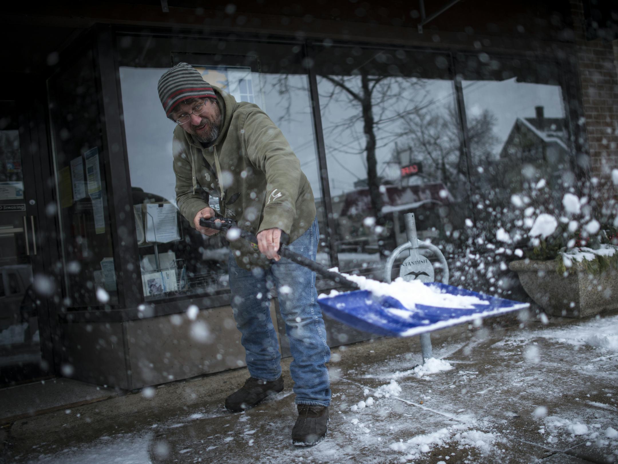 Chris Donnelly, owner of Southside Vintage, shoveled snow from the front of the neighboring Standish Ericsson Neighborhood Association office on Saturday afternoon.