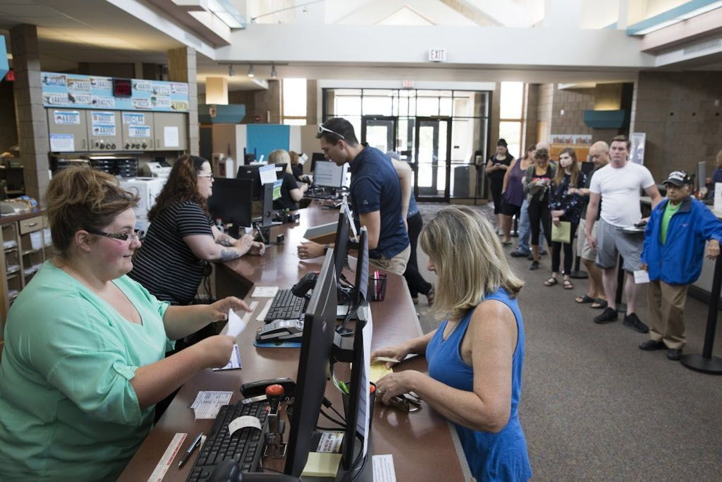 Service representative Jacquelyn Lebeis, left, helps a customer at the Woodbury License Center.