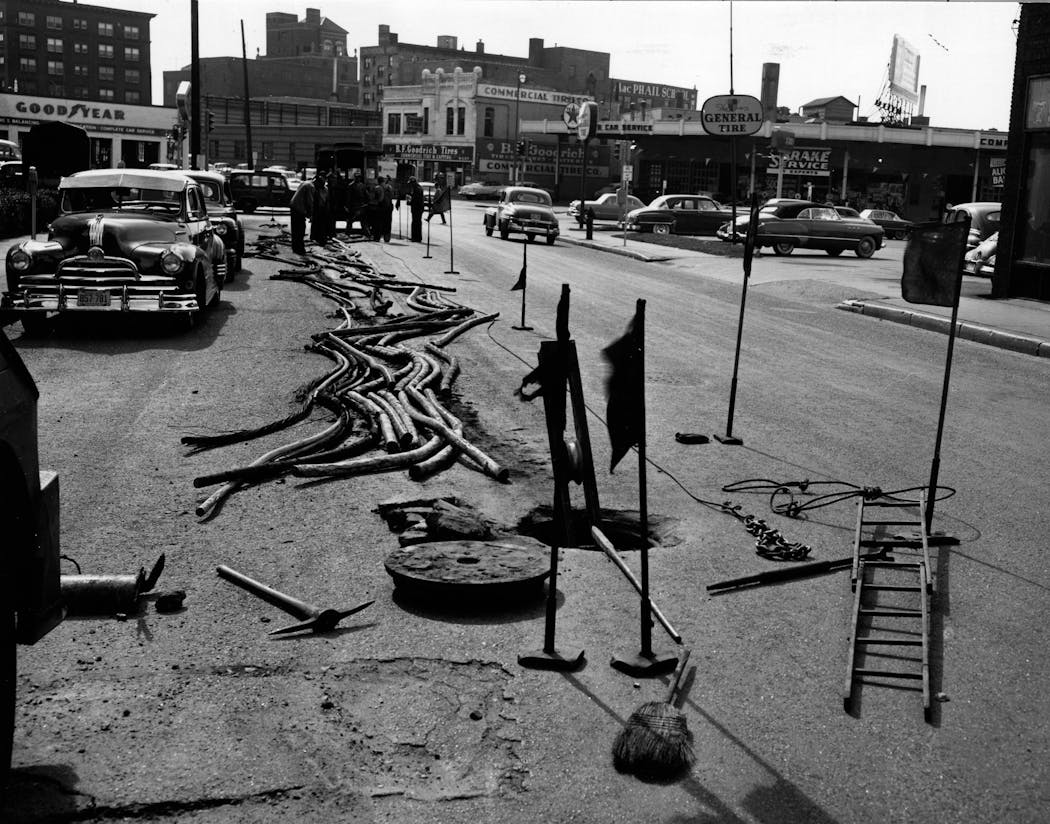 Underground streetcar power cables are pulled from 11th Street and Hennepin Avenue in 1954.