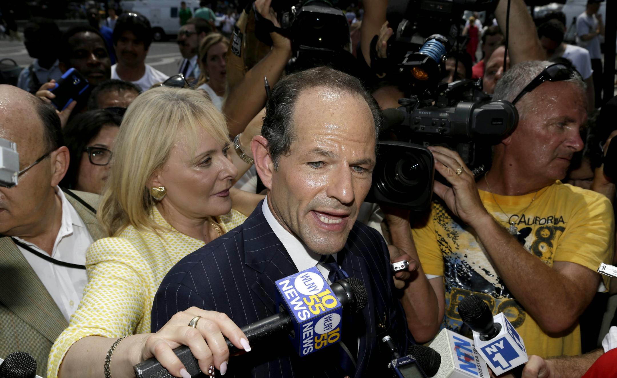 Former New York Gov. Eliot Spitzer is surrounded by media as he tries to collect signatures for his run for New York City Comptroller in New York, Monday, July 8, 2013. Spitzer, who stepped down in 2008 amid a prostitution scandal, says he is planning a political comeback with a run for New York City comptroller.(AP Photo/Seth Wenig)