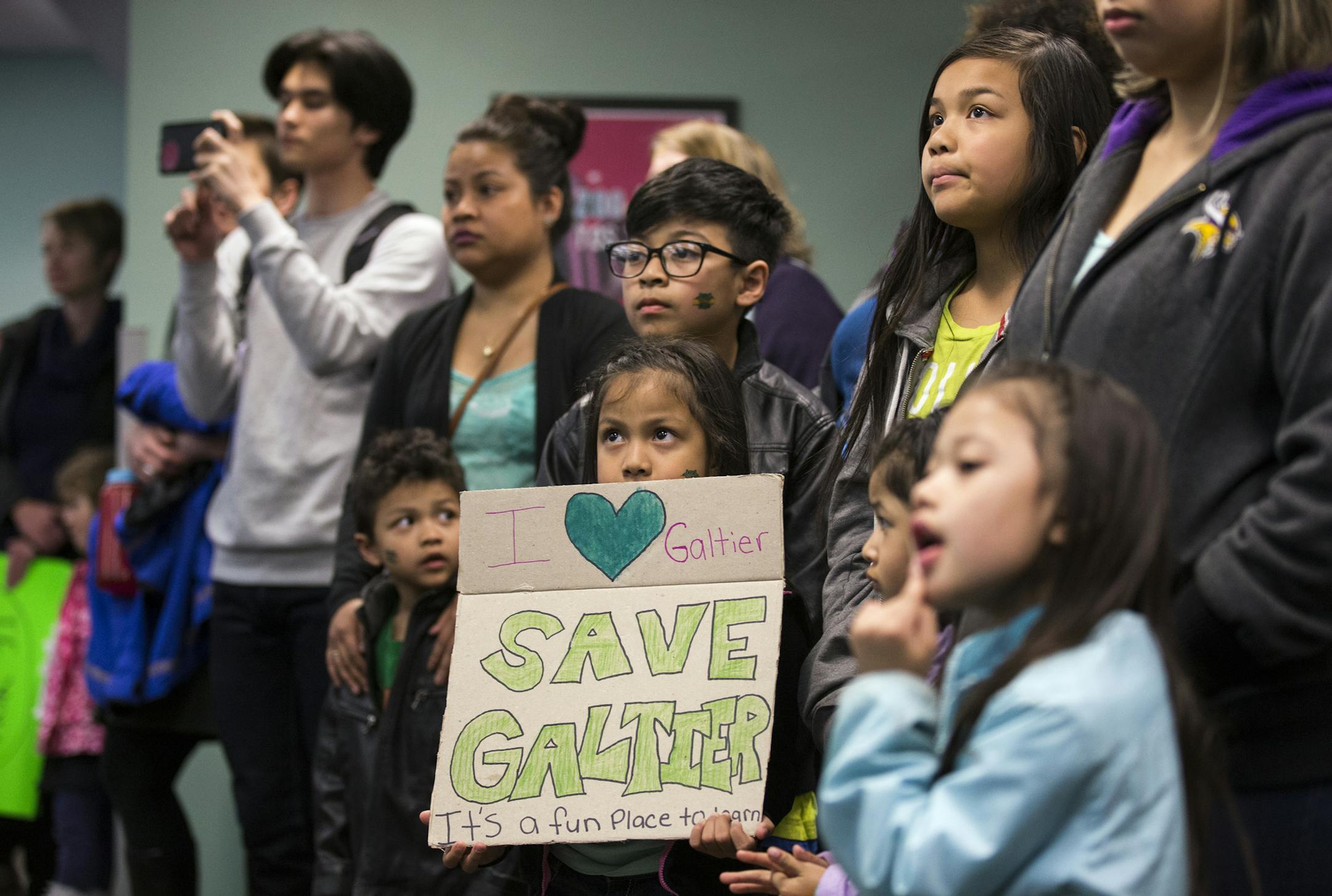 Galtier Community School first grader Jalyssa Sengdara, 7, center, holds a sign during the public comment portion of a St. Paul School Board meeting. ] (Leila Navidi/Star Tribune) leila.navidi@startribune.com BACKGROUND INFORMATION: Tuesday, April 26, 2016 at St. Paul School District headquarters. With a plan for $484 million in capital projects awaiting its approval, the St. Paul school board on Tuesday heard from a group of parents and students with a different aim. They are fighting to save G