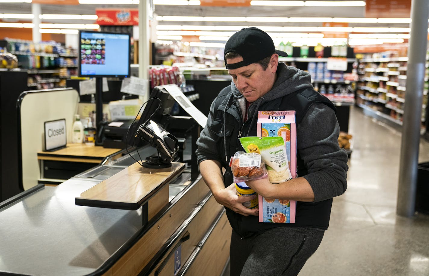 Sarah Hachey carried her groceries out without a bag at North Market on Thursday, a day after Minneapolis' new rule took effect charging shoppers 5 cents for bags