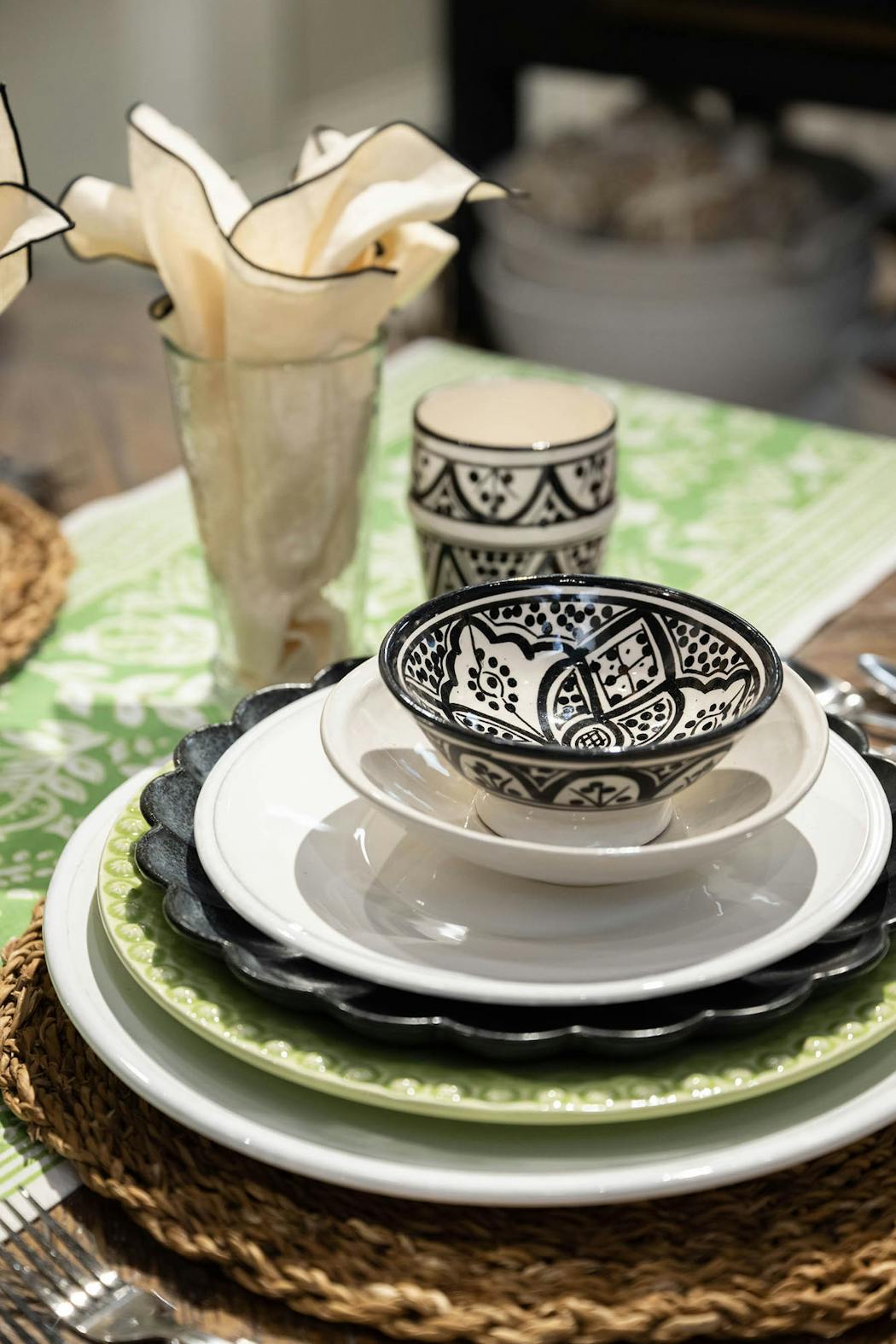 A pop of green in the dishes adds continuity to the design while white and black painted dishes add interest and texture.