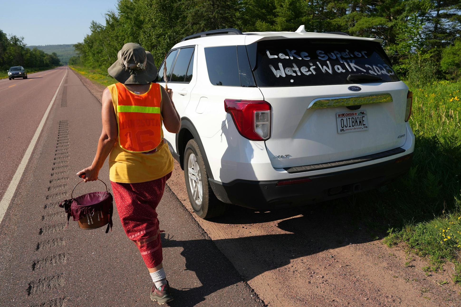 Jane Ramseyer Miller, one of five core walkers making the entire journey, passes one of the caravan's vehicles.