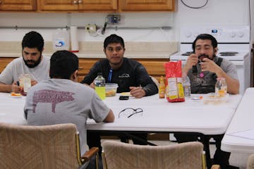 Josue Ramirez, left, and several other employees at Hugoson Pork take their lunch break at a sow barn near Granada, Minn. Ramirez, of Monterrey, Mexic