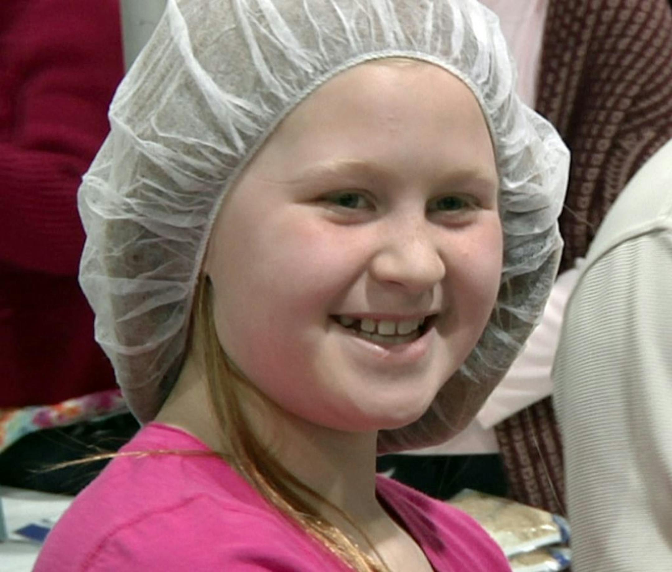 In this Friday, Feb. 14, 2014 photo, Jenna Stewart, 10, of Garden City, Mich., smiles while packing food for the malnourished during the 2 Million Meals event in Novi, Mich.