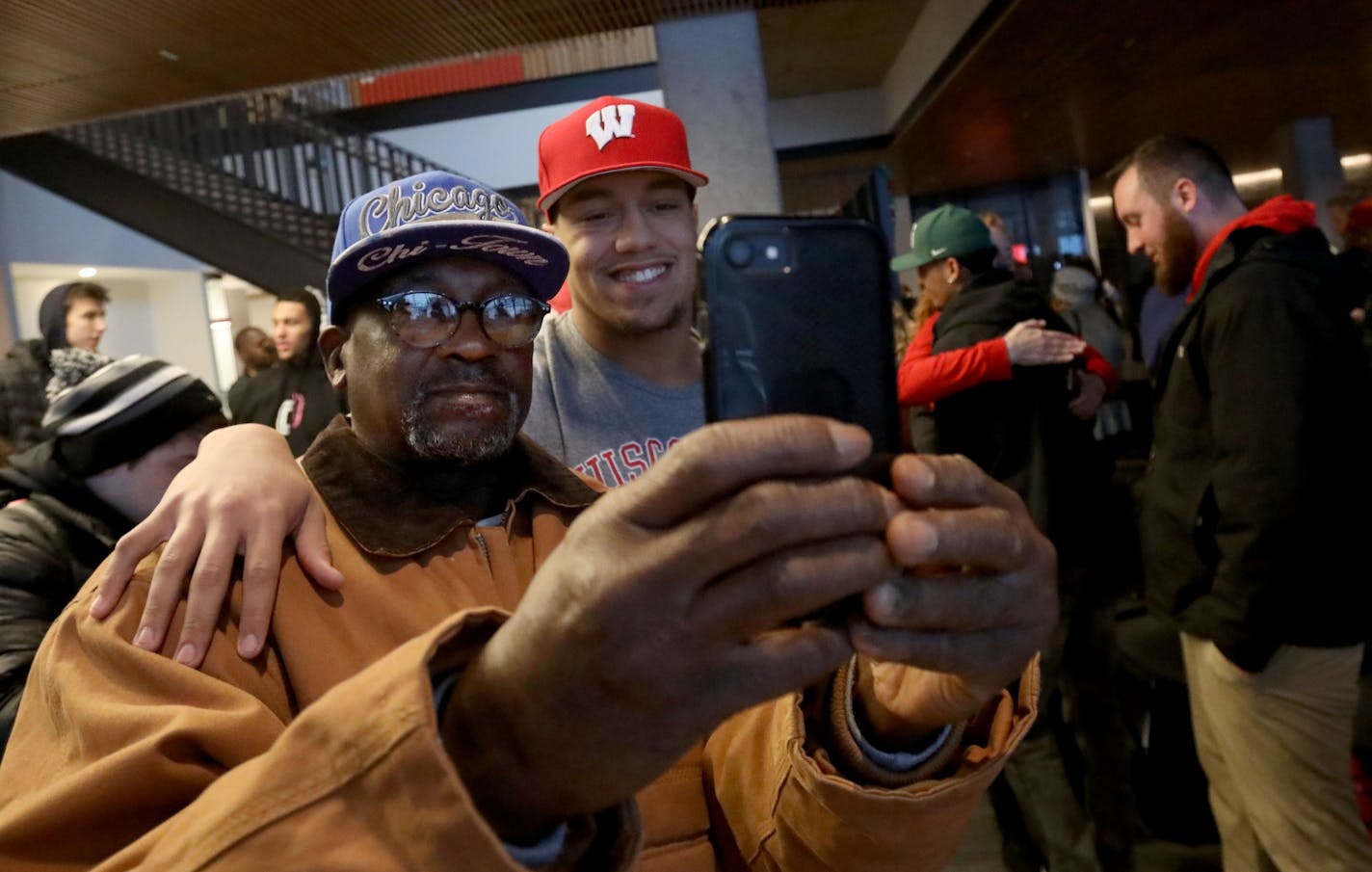 Minnehaha Academy football products Kaden Johnson takes a photo with his grandfather,Jimmy Johnson, during a national signing day ceremony.