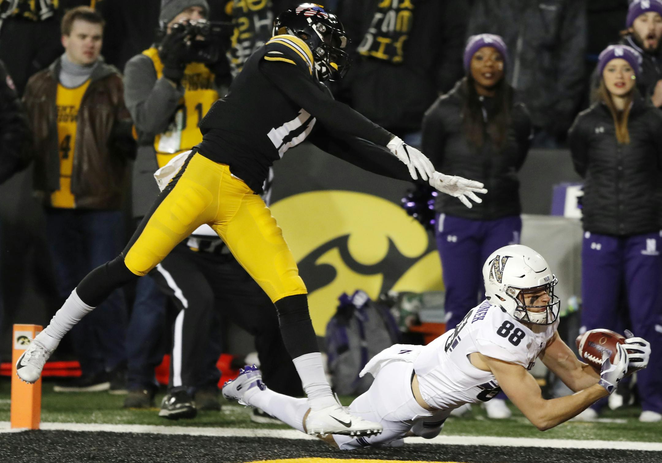 Northwestern wide receiver Bennett Skowronek catches a 32-yard touchdown pass ahead of Iowa defensive back Michael Ojemudia, left, during the second half of an NCAA college football game, Saturday, Nov. 10, 2018, in Iowa City, Iowa. Northwestern won 14-10. (AP Photo/Charlie Neibergall)
