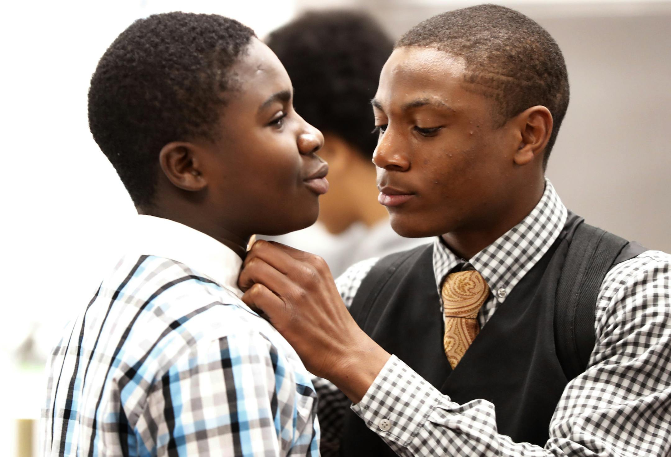Emmanuel Ogboru right a senior receiver at Cooper High School Wednesday helped freshman Manasseh Williams with his shirt during dressed for success Wednesday September 28, 2016 in St. New Hope, MN. ] Cooper football coach Willie Howard has installed a Dress For Success program, where football players wear dress shirts and ties on Mondays and Wednesdays. Jerry Holt / jerry. Holt@Startribune.com