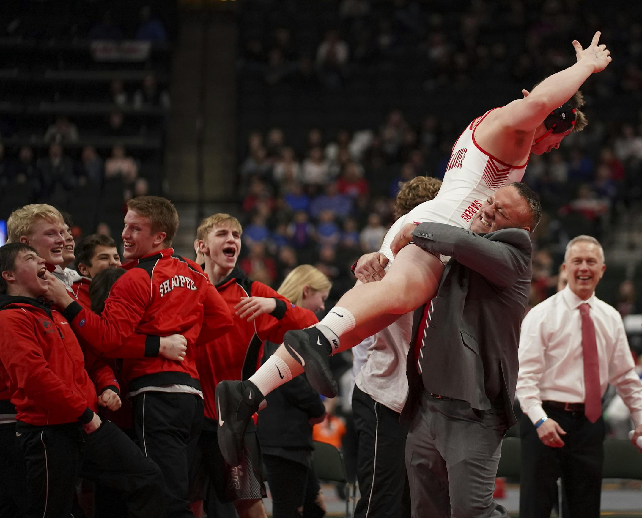 Shakopee assistant coach Nick Slack hoisted Ben Reiland aloft after he won his heavyweight match by a fall in just 16 seconds. ] JEFF WHEELER • Jeff.Wheeler@startribune.com Shakopee defeated Stillwater 34-21 to take the Class 3A State High School Wrestling Tournament Team Championship Thursday night, February 27, 2020 at Xcel Energy Center in St. Paul.