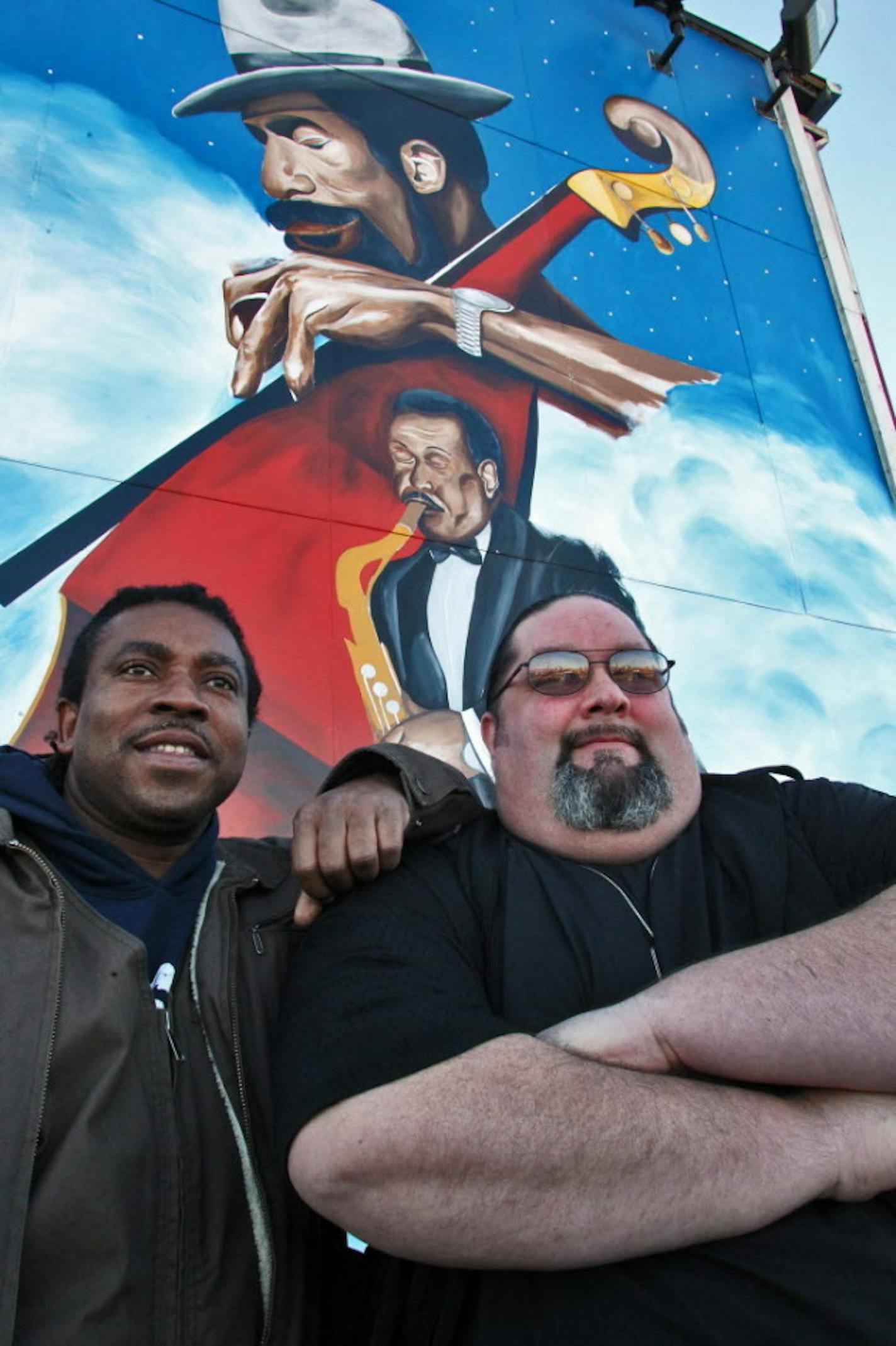 Artist Charles Caldwell and Bar Manager Mike Oker stand in front of the mural Caldwell created on the side of the 4th Street Saloon. Photo by Marlin Levison