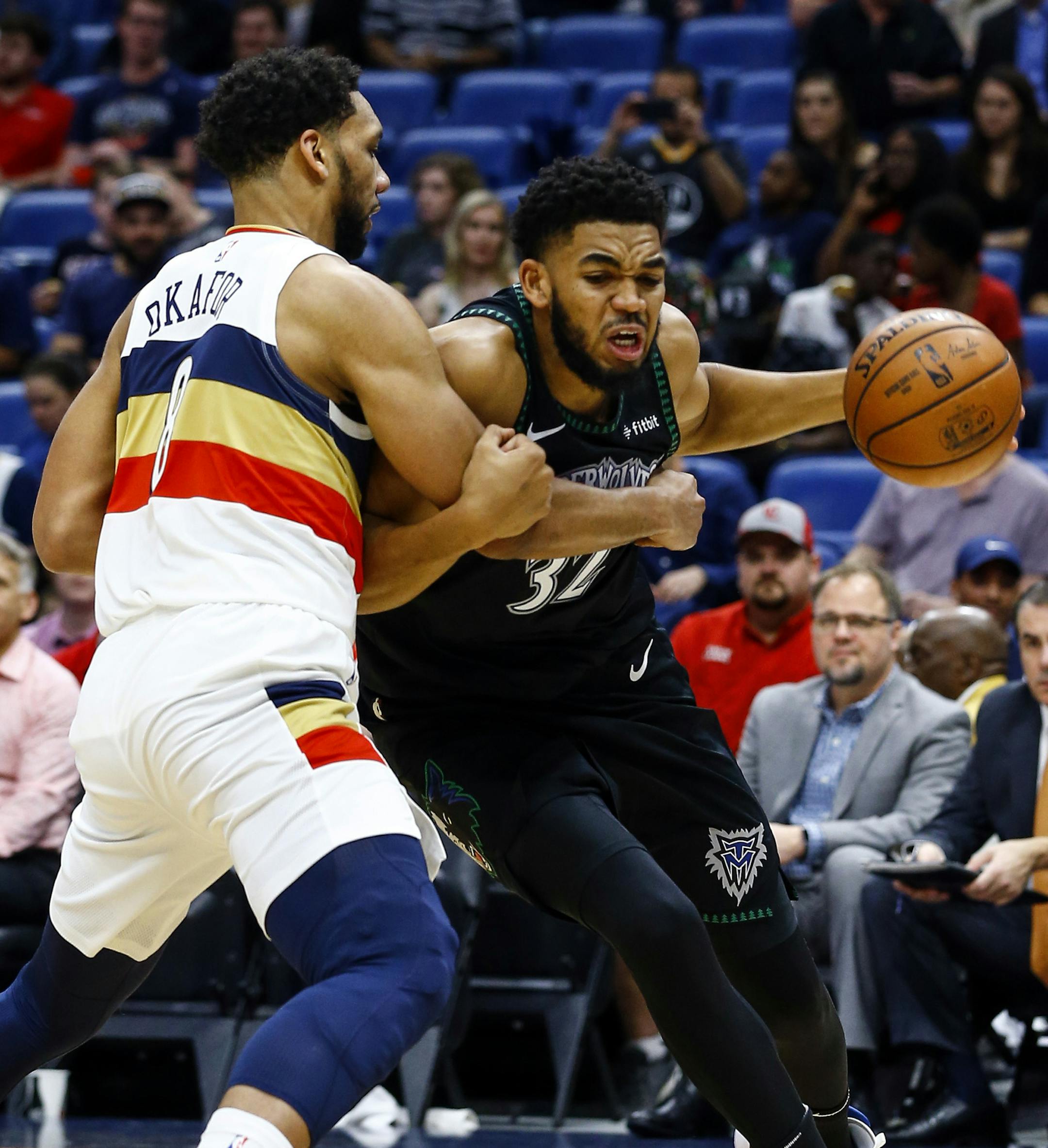Minnesota Timberwolves center Karl-Anthony Towns (32) is fouled by New Orleans Pelicans center Jahlil Okafor (8) as he drives to the basket during the first half of an NBA basketball game, Monday, Dec. 31, 2018, in New Orleans. (AP Photo/Butch Dill)