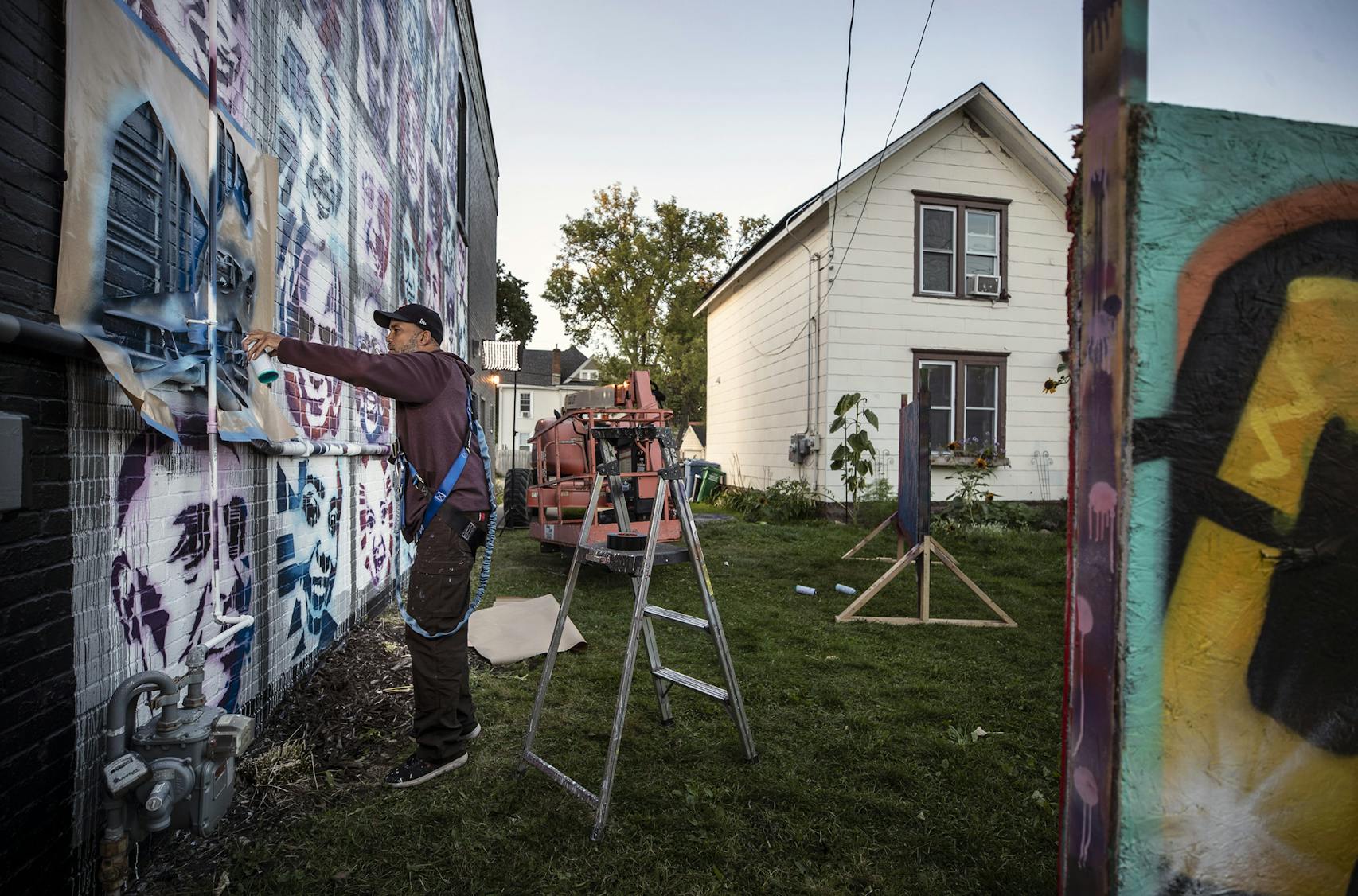 Artist Peyton Scott Russell worked on an elaborate mural at City of Lakes Community Land Trust in north Minne­apolis — one that utilizes stencils of people that they helped create themselves. 