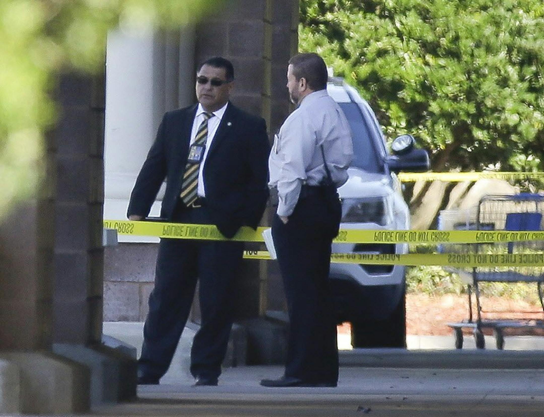 Law enforcement officials stand near the entrance to a Walmart where a police officer was shot, Monday, Jan. 9, 2017, in Orlando, Fla. Orlando police say the officer who was shot while on duty has died; a manhunt is underway for the suspect.
