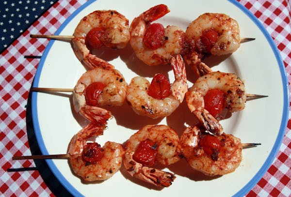 Skewering shrimp on the grill, such as these shrimp and sausage skewers with smoky paprika glaze, prevents the risk of losing a shrimp through the gra