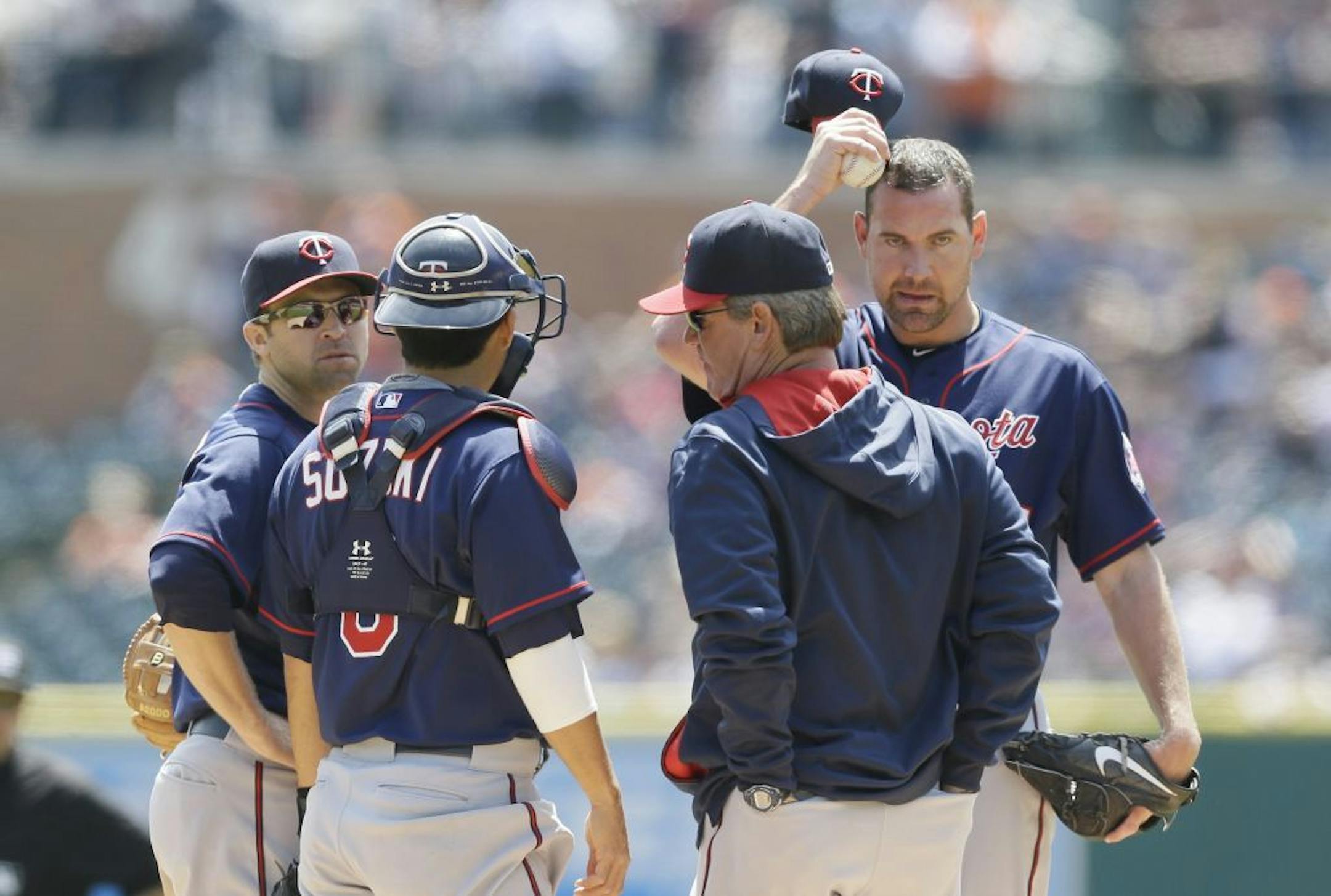 Minnesota Twins starting pitcher Mike Pelfrey, right, stands on the mound as pitching coach Neil Allen, catcher Kurt Suzuki and second baseman Brian Dozier confer during the first inning of a baseball game against the Detroit Tigers, Thursday, May 14, 2015, in Detroit.