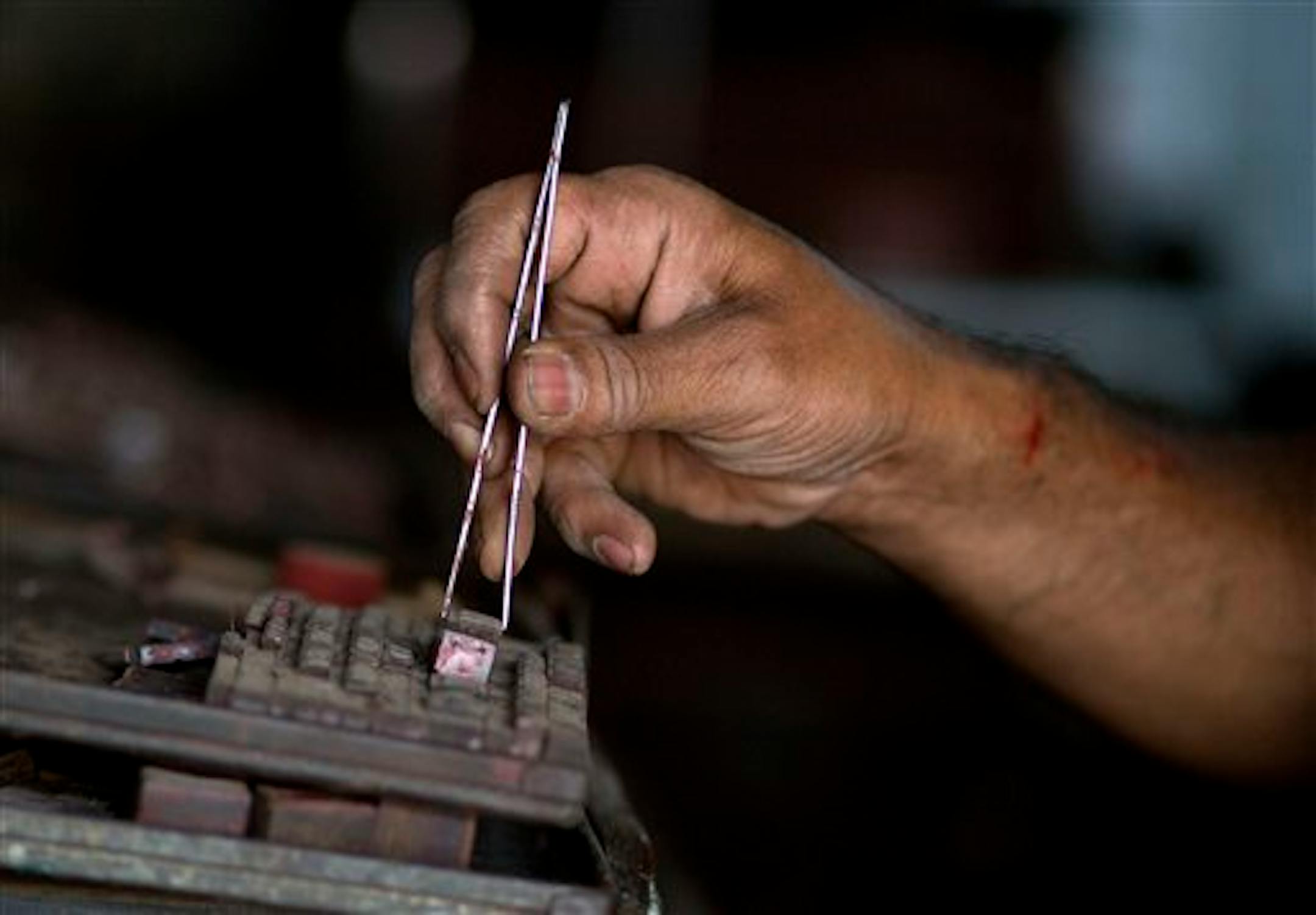 In this Thursday, April 16, 2015 photo, Basab Seal, 65, composes matter manually at his printing press in Gauhati, India. Basab Seal is going to close down his treadle-operated printing business as it has been incurring a loss, being no match for newer technology. (AP Photo/ Anupam Nath)