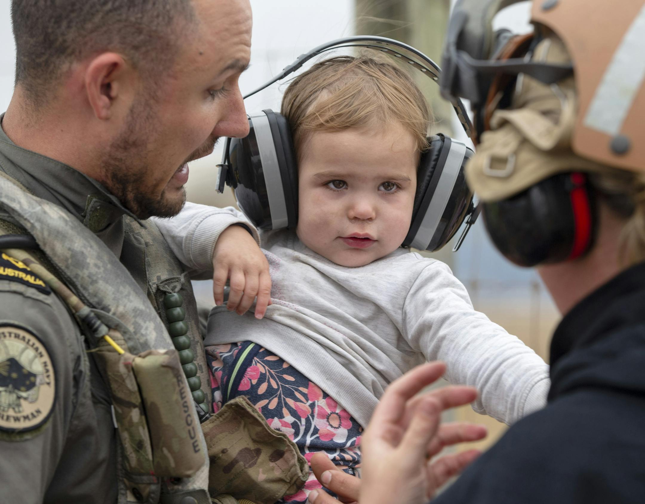 In this photo provided by the Australian Department of Defence, a child is helped onto a helicopter as the fire ravaged community of Mallacoota is evacuated, Sunday, Jan. 5, 2020. The wildfires have so far scorched an area twice the size of the U.S. state of Maryland. (Corporal Nicole Dorrett/ADF via AP)
