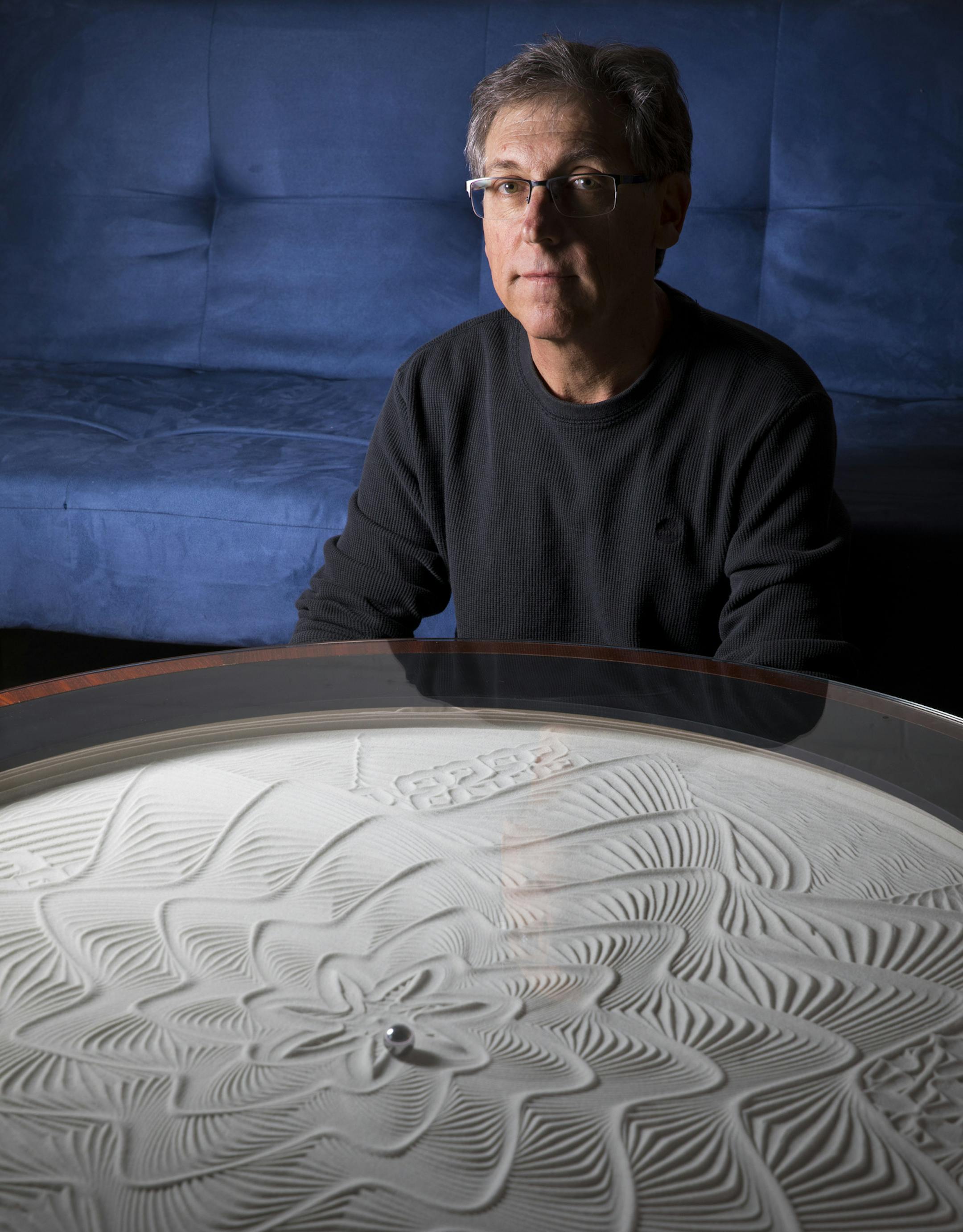 Bruce Shapiro of Minneapolis has made large-scale moving art pieces found in science museums. His latest project is a glass-topped coffee table called Sisyphus, featuring a magnet-driven ball rolling over a layer of sand, “forever creating and erasing beautiful patterns.”