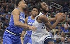 Minnesota Timberwolves forward Andrew Wiggins (22) is fouled by Orlando Magic center Khem Birch, left, while driving to the basket during the first ha