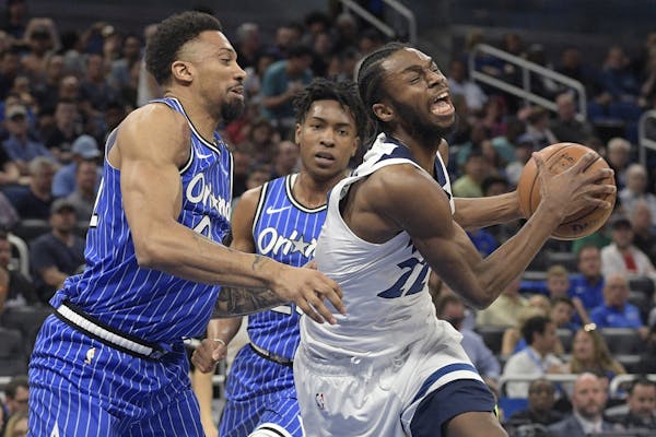 Minnesota Timberwolves forward Andrew Wiggins (22) is fouled by Orlando Magic center Khem Birch, left, while driving to the basket during the first ha