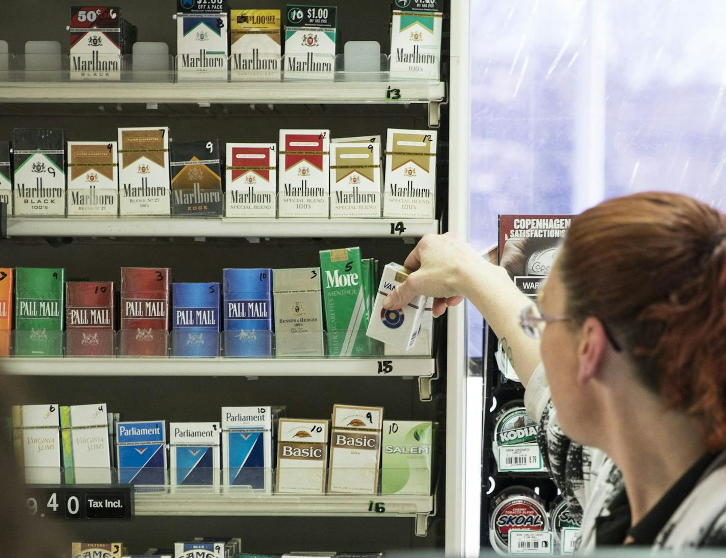 Michelle Kennedy grabbed a pack of cigarettes behind the counter for a customer at Vernon BP gas station in Edina. St. Louis Park is poised to become the second city in the state to raise the tobacco sales age from 18 to 21.