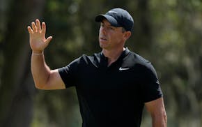 Rory McIlroy waves after making a birdie putt on the ninth hole during the first round of The Players Championship.