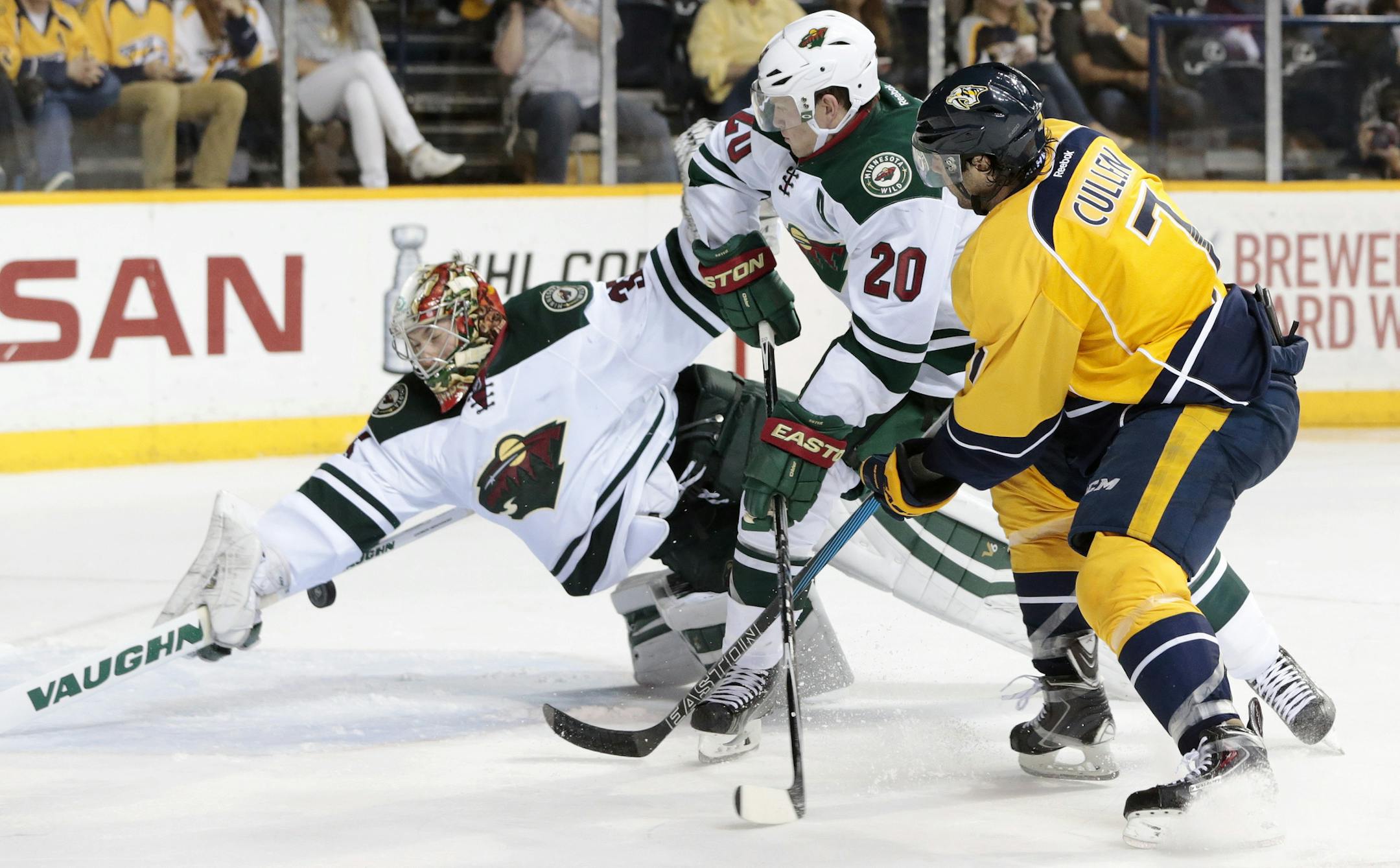 Minnesota Wild goalie Darcy Kuemper dives for a shot by Nashville Predators center Matt Cullen (7) in the third period of an NHL hockey game Thursday, April 9, 2015, in Nashville, Tenn. Minnesota's Ryan Suter (20) also defends. (AP Photo/Mark Humphrey)