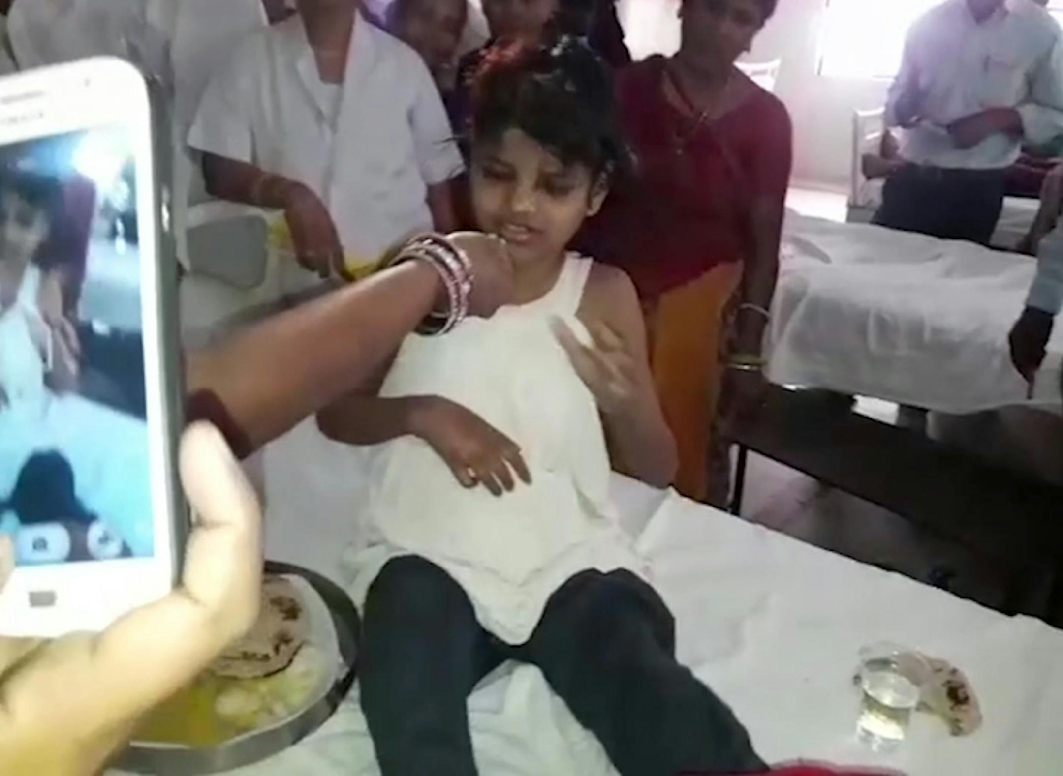 A young Indian girl sits on a bed at a hospital in this image taken from video in Bahraich northern India Thursday April 6, 2017. Indian police are reviewing reports of missing children from recent years to try to identify the girl who was found in a forest with a group of monkeys. The girl, believed to be about 10 to 12 years old, was unable to speak, was wearing no clothes and was emaciated when she discovered in January and taken to a hospital in Bahraich. (KK Productions, via AP)