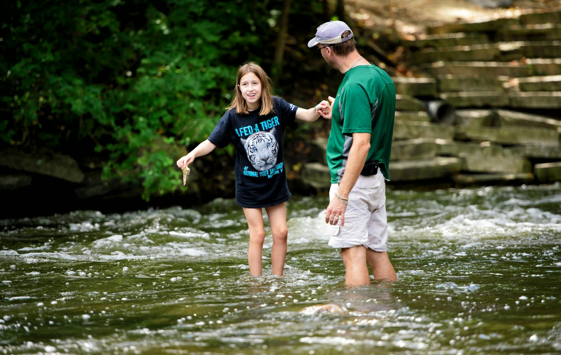 Katelyn Mattson, 10, got a helping hand from her dad Gene as the two hunted for cool rocks in the swiftly moving waters below Minnehaha Falls, Minneapolis.