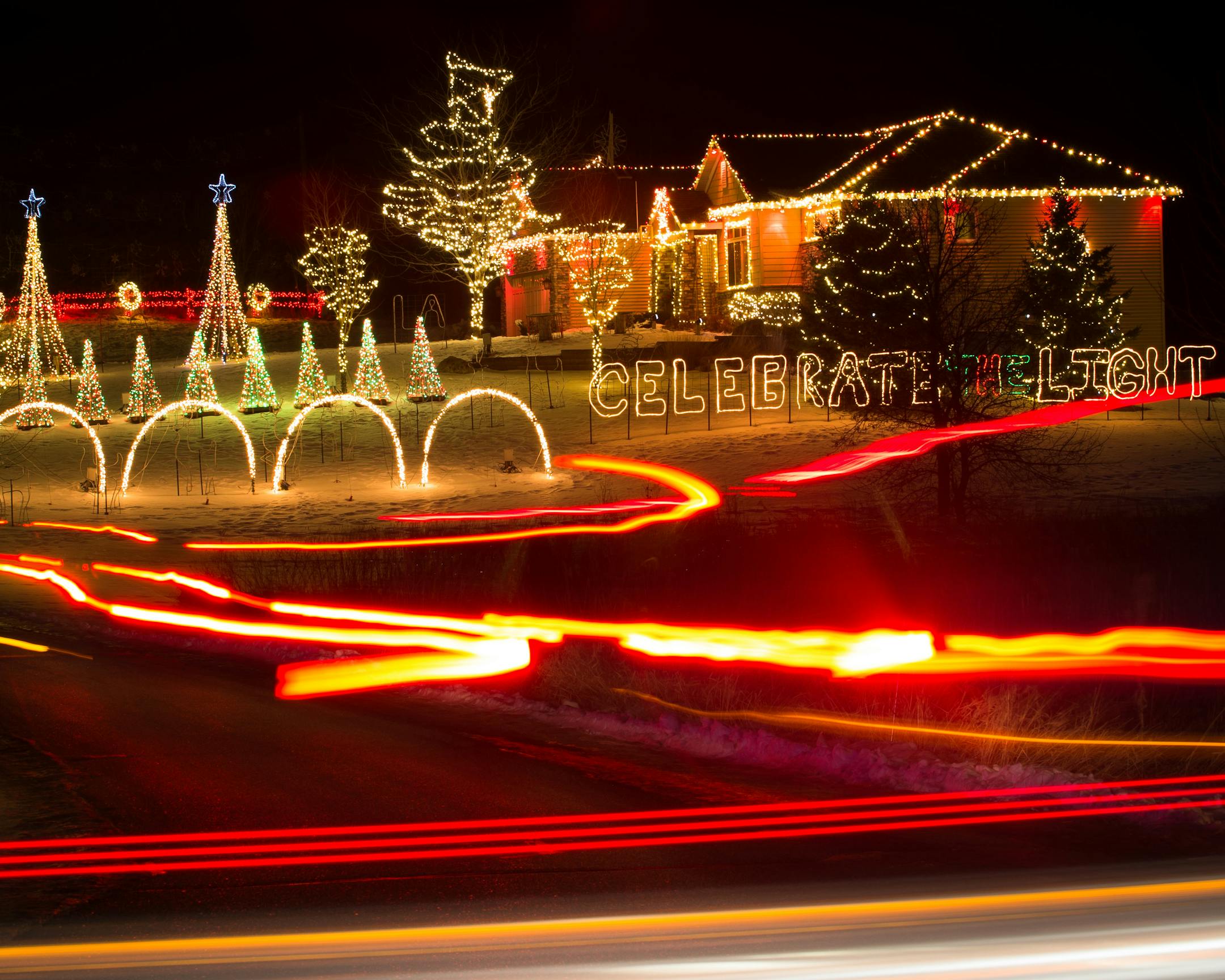 Head and tail lights from visiting cars leave light trails as they drive through an elaborate Christmas light display in Willmar.