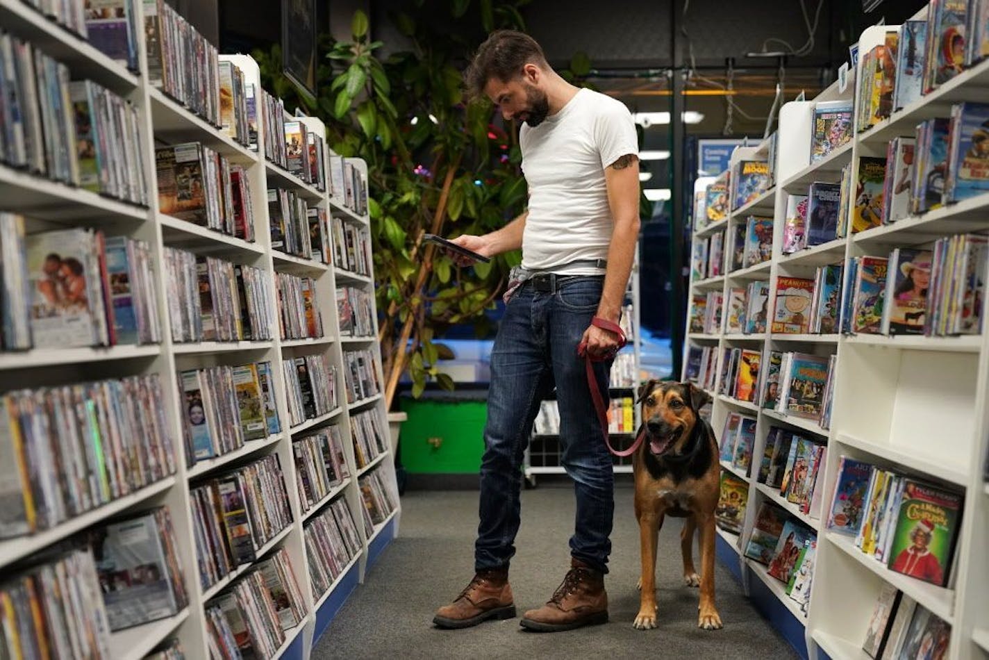 Garrett Fitzgerald browsed the DVDs for sale along with his housemate's dog Hondo at The Movies on 35th Street.