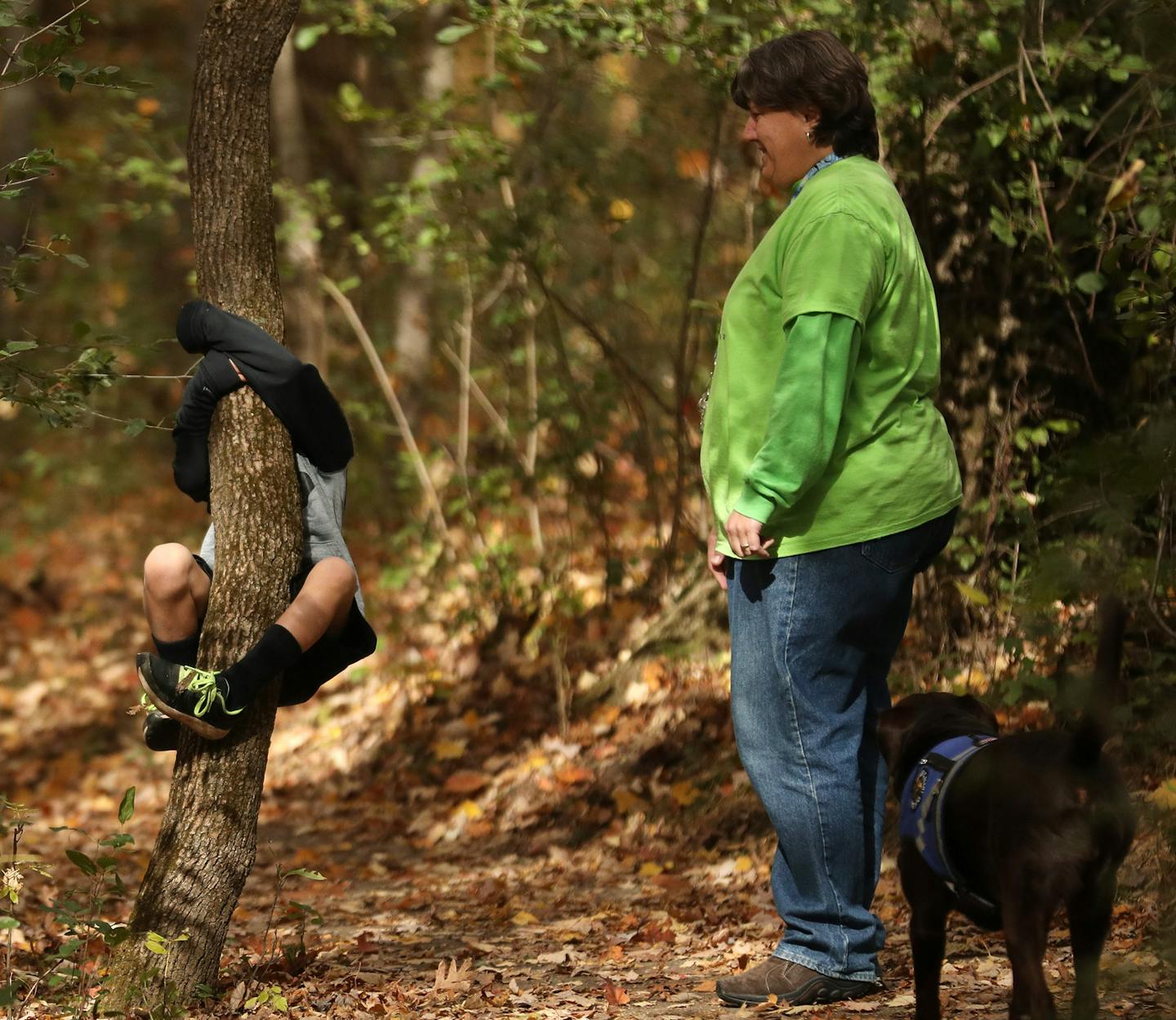 Teacher Molly Kaliher and her service dog Hope stopped to allow a student to climb a tree while walking between classes. ] ANTHONY SOUFFLE &#xef; anthony.souffle@startribune.com Students spent a typical school day in a unique setting at River Grove, new charter school with an emphasis on environment and the arts, Wednesday, Oct. 18, 2017 near Marine on St. Croix, Minn. The school is housed in a series of buildings at a former retreat complex surrounded by forest.