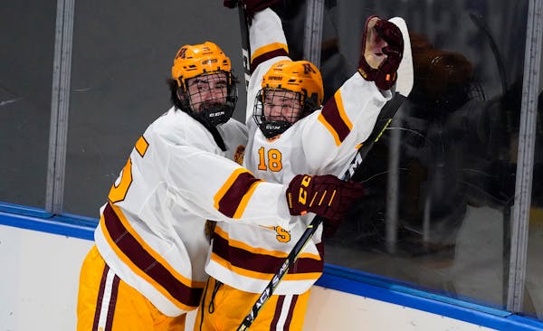 Minnesota forward Mason Nevers, right, celebrates his goal with forward Jack Perbix during the first period of an NCAA West Regional college hockey se