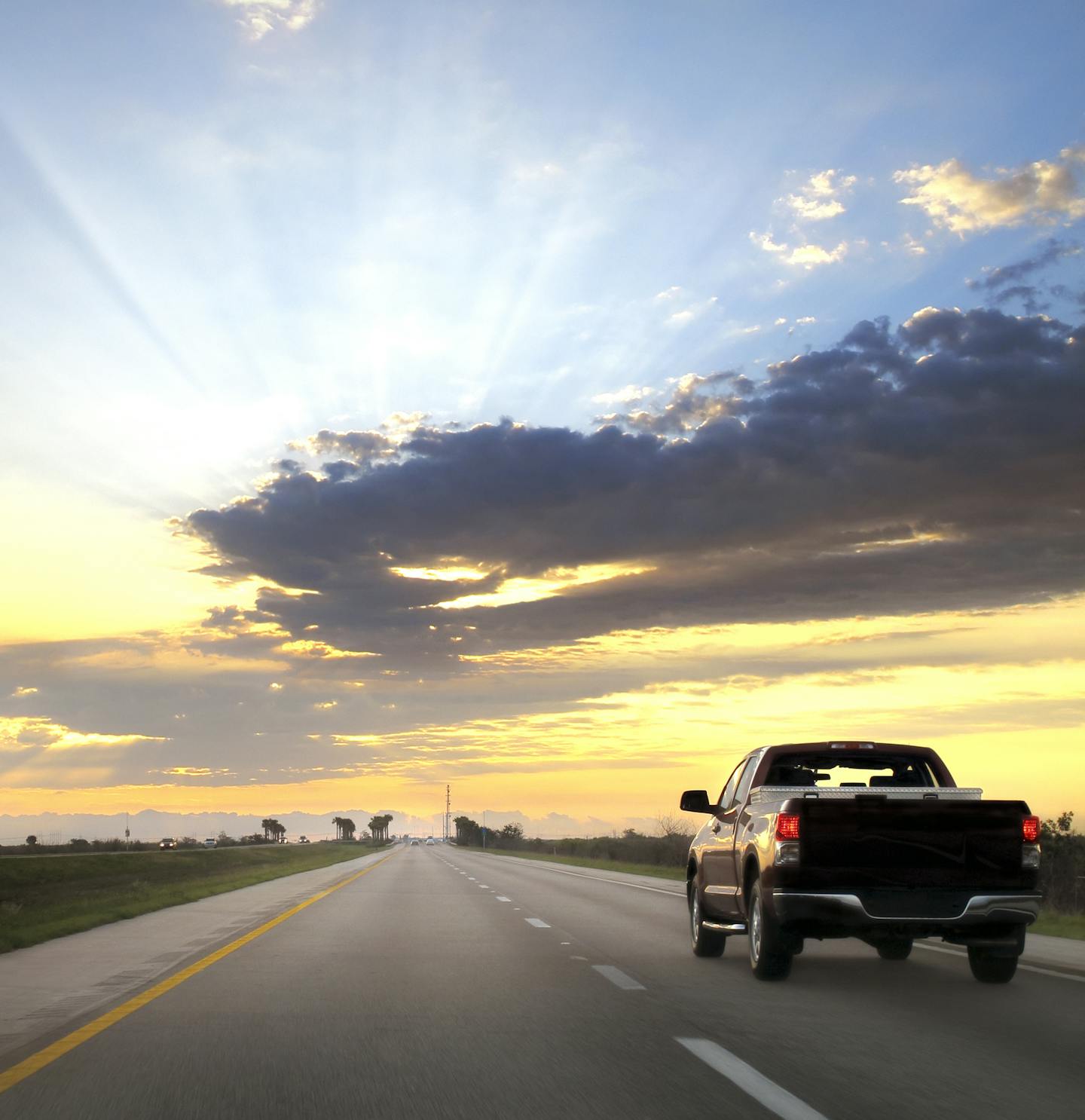 Pick up truck driving on highway during sunrise in Miami, Florida.