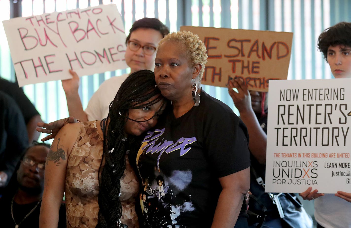 Tecara Ayler, a tenant of discredited landlord Mahmood Khan, rested her head on the shoulder of fellow renter Patricia Grant after Friday's meeting.