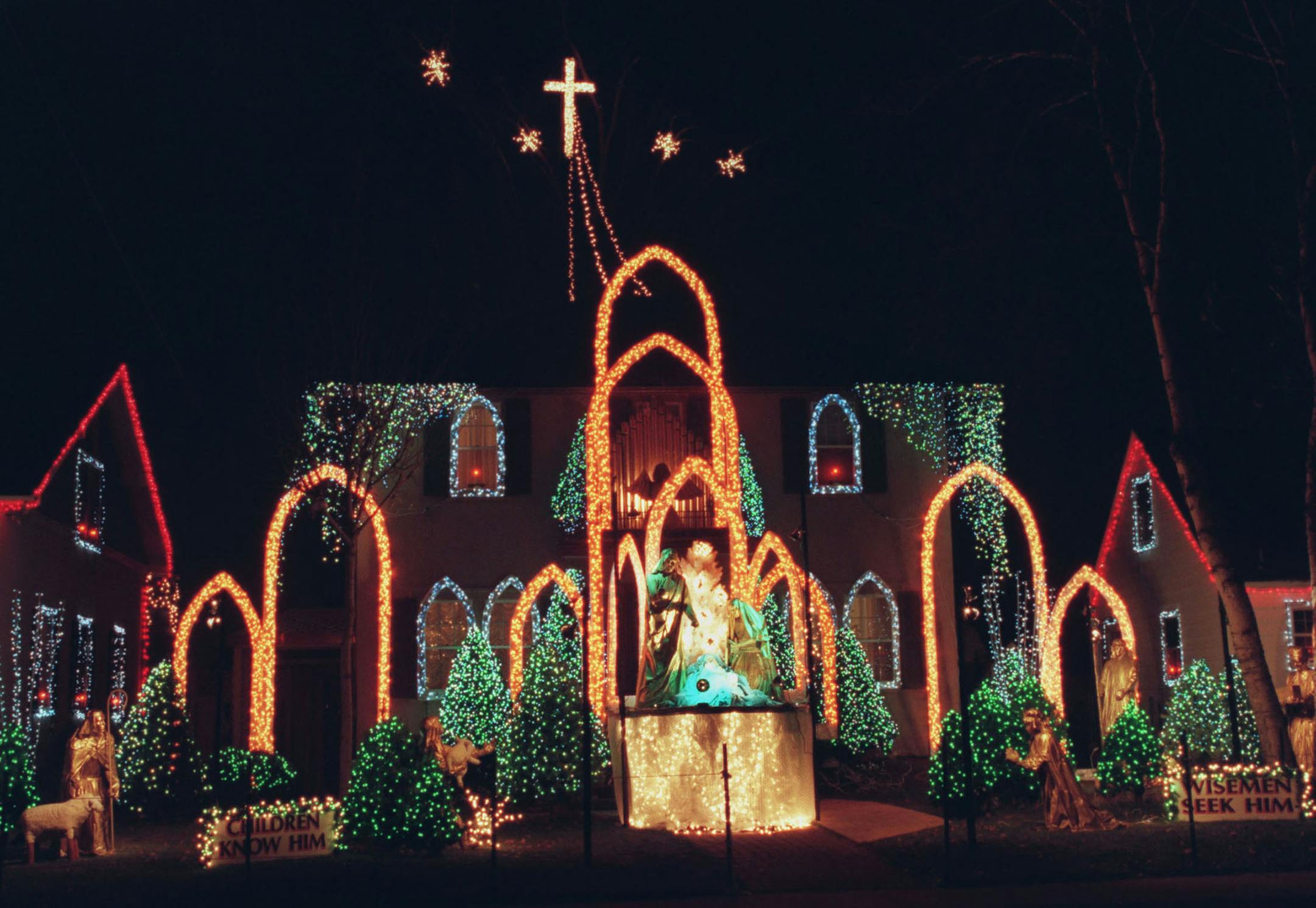 CORRECTION: The cross at top was incorrectly identified as a crucifix. (JPhil). Photographer caption follows. // The holiday light display at the home of Paul Damon of 1st Avenue South in Minneapolis. -- The holiday light display at the Damon home on 1st Avenue South in Minneapolis has a religious theme, with shepherds, angels, and an elaborate manger scene in the front yard and a crucifix high above the roof. ORG XMIT: MIN2013122312084641