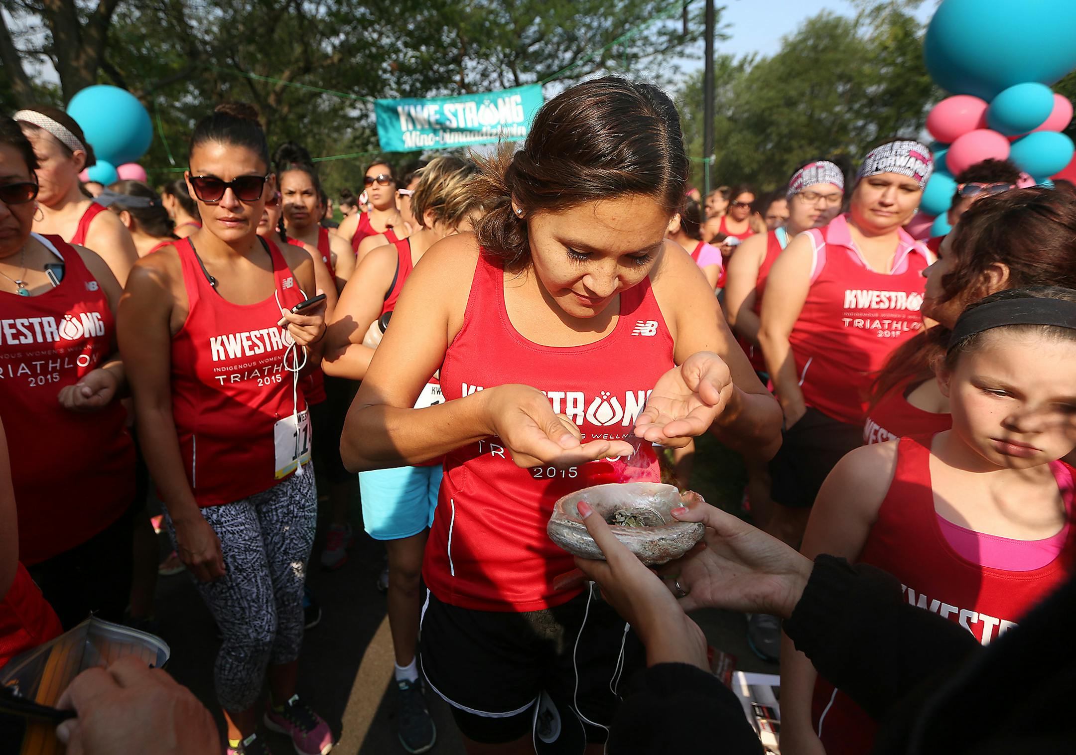 Women, mostly Native American, stood in line to smudge sage before completing the 2015 KWESTRONG women's triathlon, Saturday, August 22, 2015 in Minneapolis, MN. The triathlon, which started with canoeing across Lake Calhoun and back , also included a 9-mile bike ride, and a choice between a 5k and a 10k run. ] (ELIZABETH FLORES/STAR TRIBUNE) ELIZABETH FLORES • eflores@startribune.com