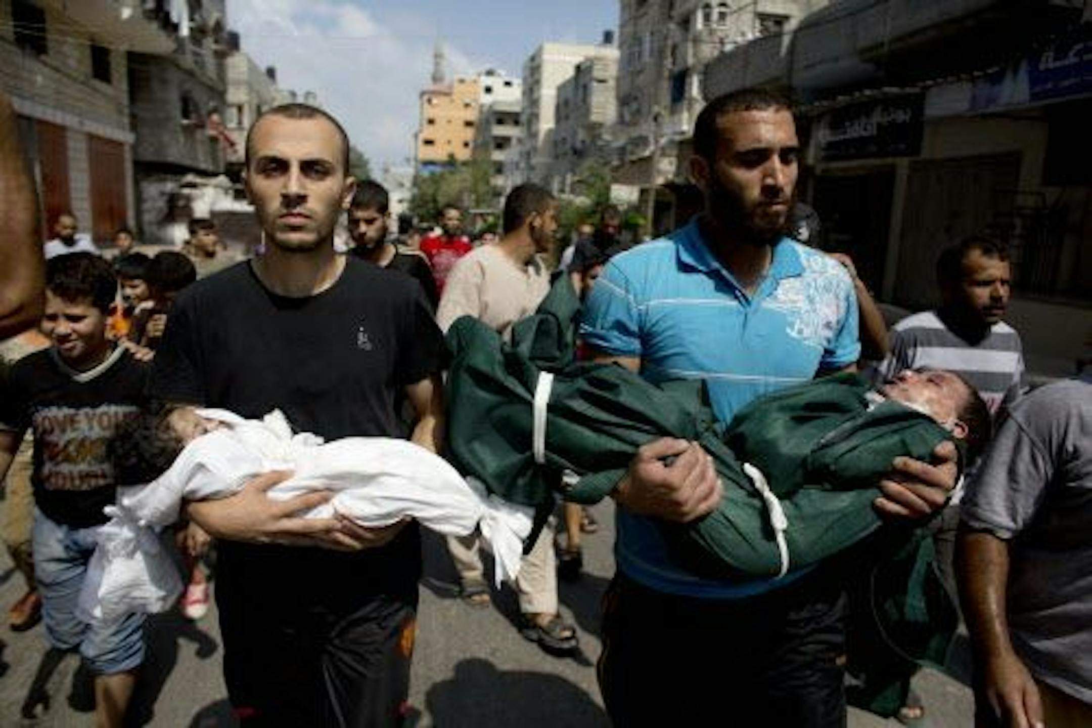Al-Bakin family members carry the bodies of three year-old Kamal and four month-old Asma during their funeral in Gaza City, Monday, Aug. 5, 2014. The children were killed along with another family member in an Israeli missile strike on their home.