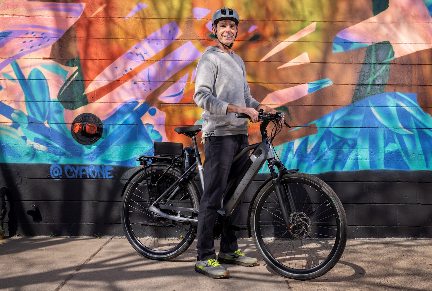 Luke Breen, owner of Perennial Cycle in Uptown Minneapolis, flashes a Gazelle Ultimate C380+ electric bike from the store.