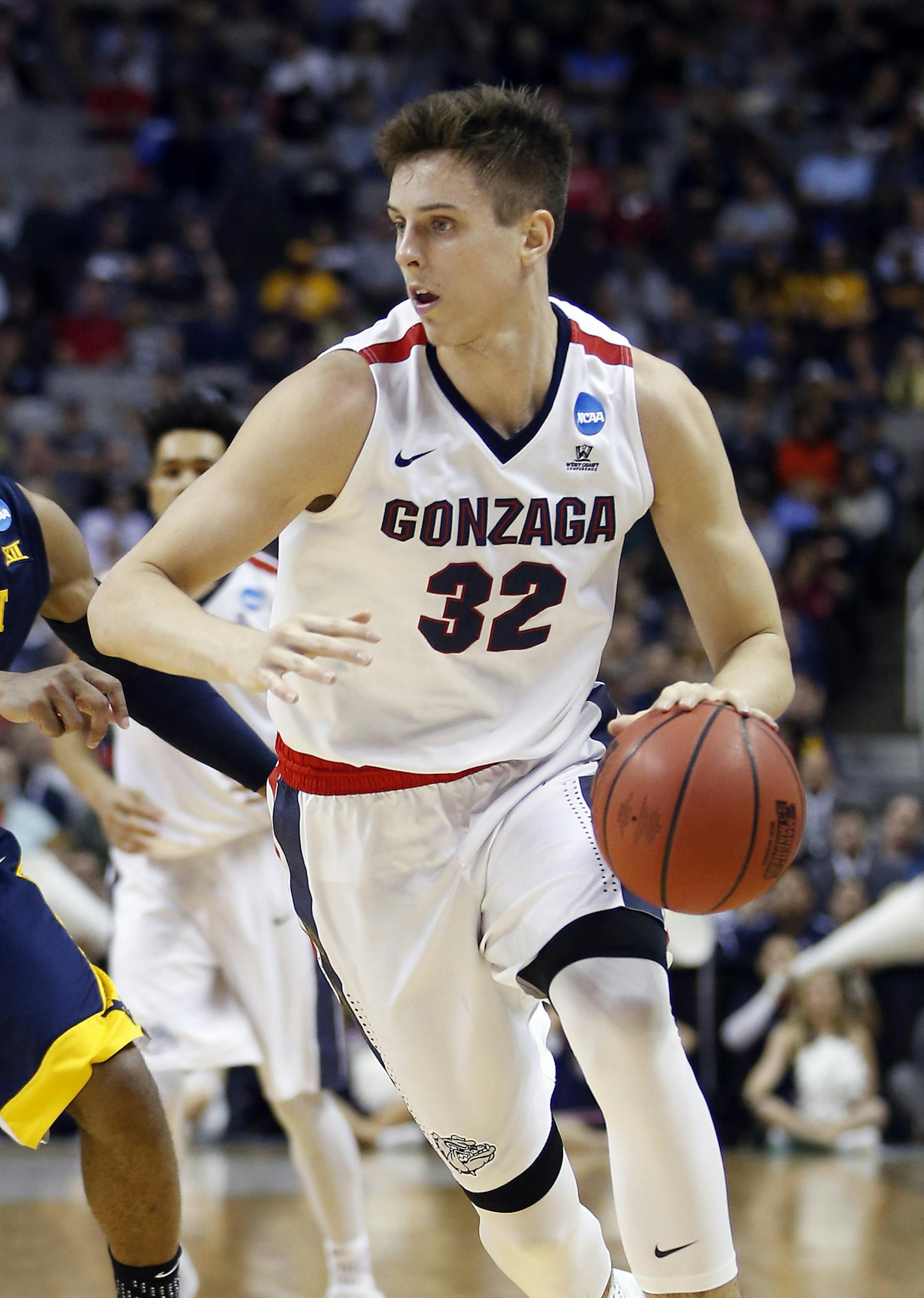 Gonzaga forward Zach Collins (32) dribbles past West Virginia guard Jevon Carter during the first half of an NCAA Tournament college basketball regional semifinal game Thursday, March 23, 2017, in San Jose, Calif. (AP Photo/Tony Avelar)
