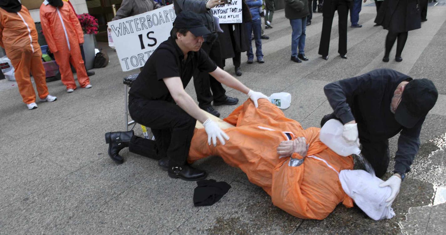 Mike Morice, center, and other members of World Can't Wait group perform a live waterboarding demonstration outside the Spanish Consulate in Manhattan to urge prosecution in Spain of the alleged involvement of Bush administration officials in the torture of terror suspects, Thursday, April 23, 2009 in New York. (AP Photo/Mary Altaffer)