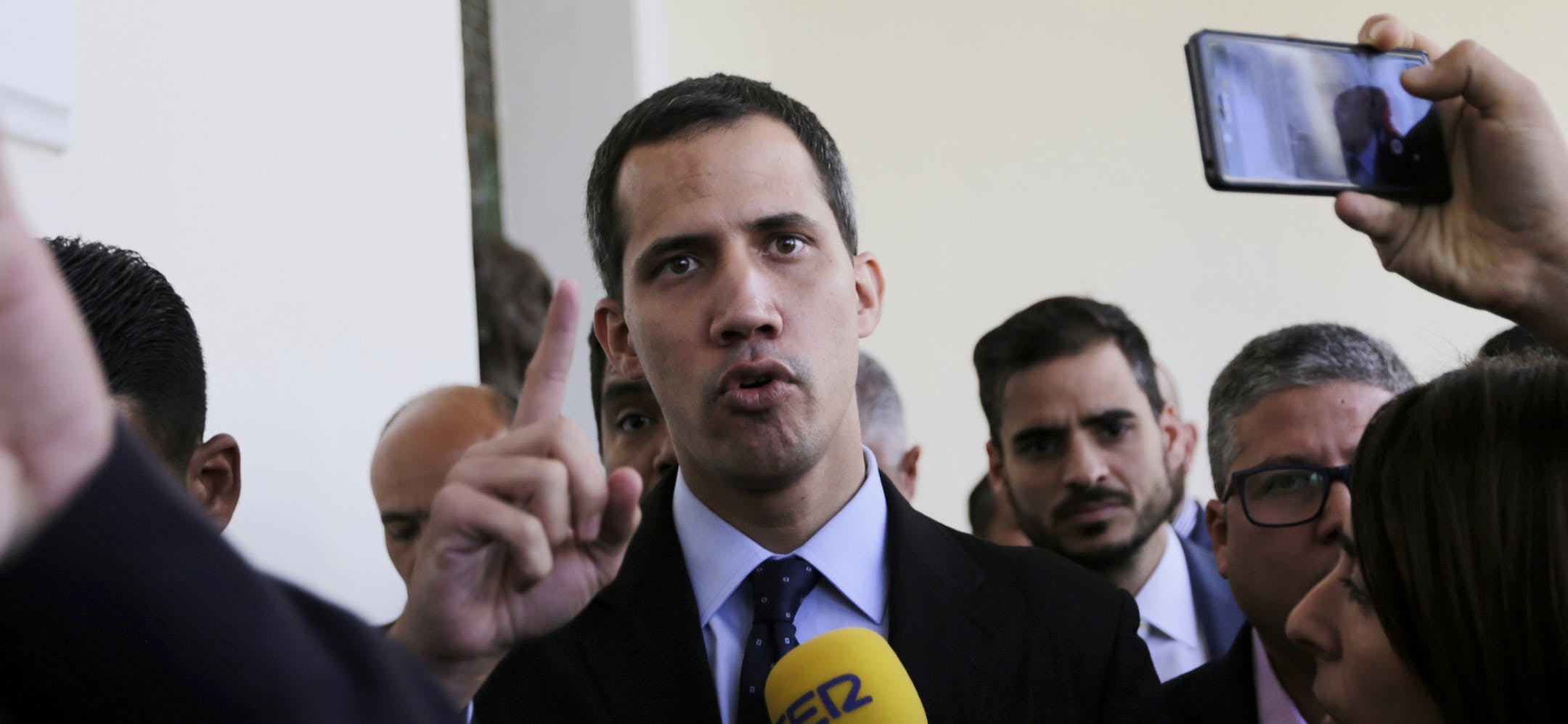 Opposition National Assembly President Juan Guaido, who has declared himself interim president of Venezuela, speaks with the media upon his arrival to National Assembly, in Caracas, Venezuela, Tuesday, Jan. 29, 2019. Venezuela's chief prosecutor on Tuesday asked the country's top court to ban opposition leader Guaido from leaving the country, launching a criminal probe into his anti-government activities while international pressure builds against President Nicolas Maduro.(AP Photo/Fernando Llan