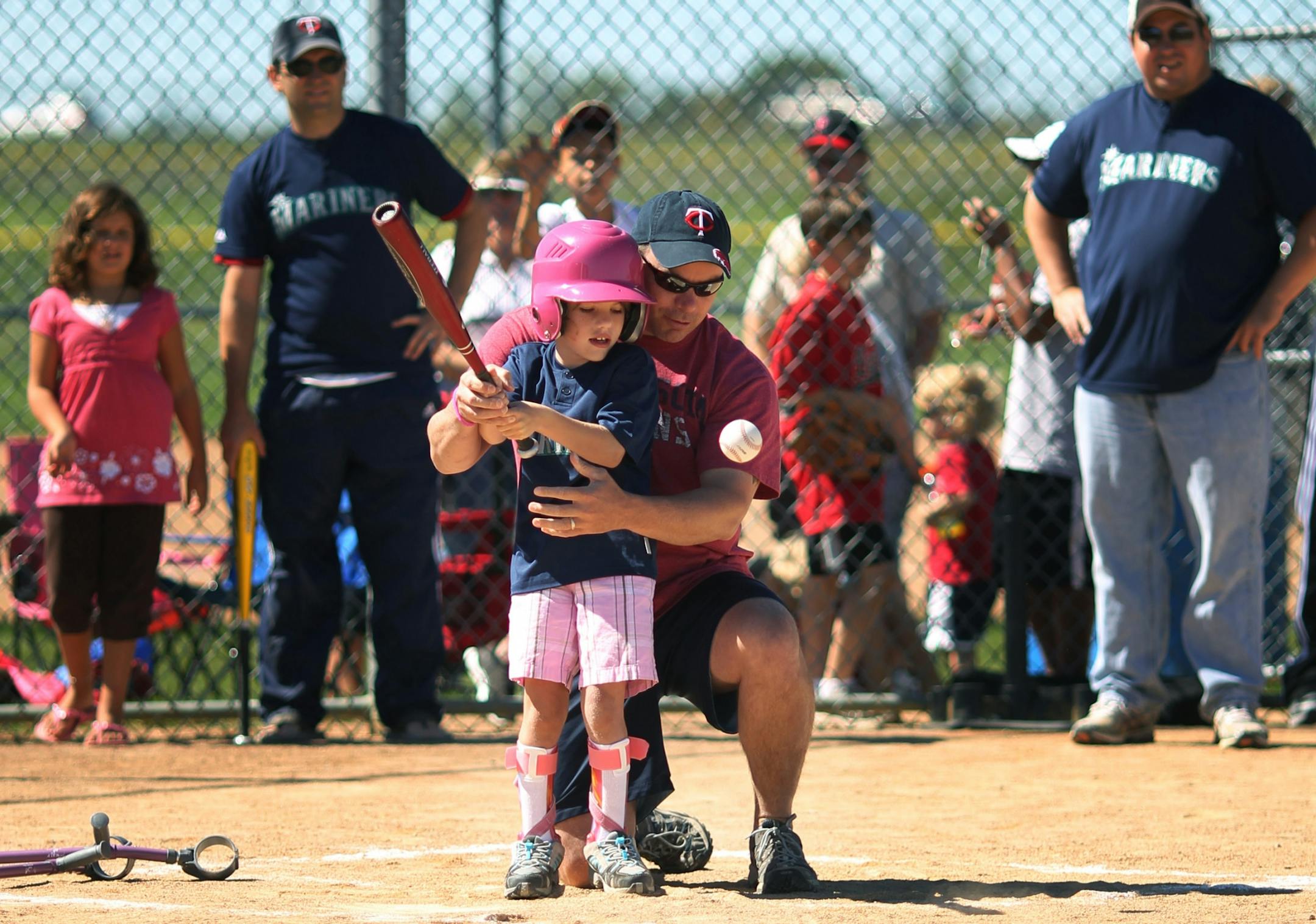 Maddy White 8, with the help of her father Derick White takes a swing at a pitch during a recent Miracle League baseball game in Lakeville. Maddy the youngest of 4 children of Derick and Cara White was born with cerebral palsy. Young Maddy spent many days in the stands watching her siblings playing baseball, and now thanks The Miracle League�s she is able too play on a baseball team with other kids. "The Miracle League" is a charitable organization that provides children with mental and/or physi