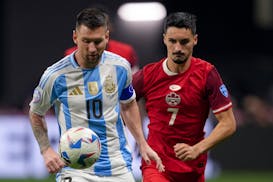 Argentina's Lionel Messi, left, and Canada's Stephen Eustaquio battle for the ball during a Copa America Group A match Thursday night in Atlanta.
