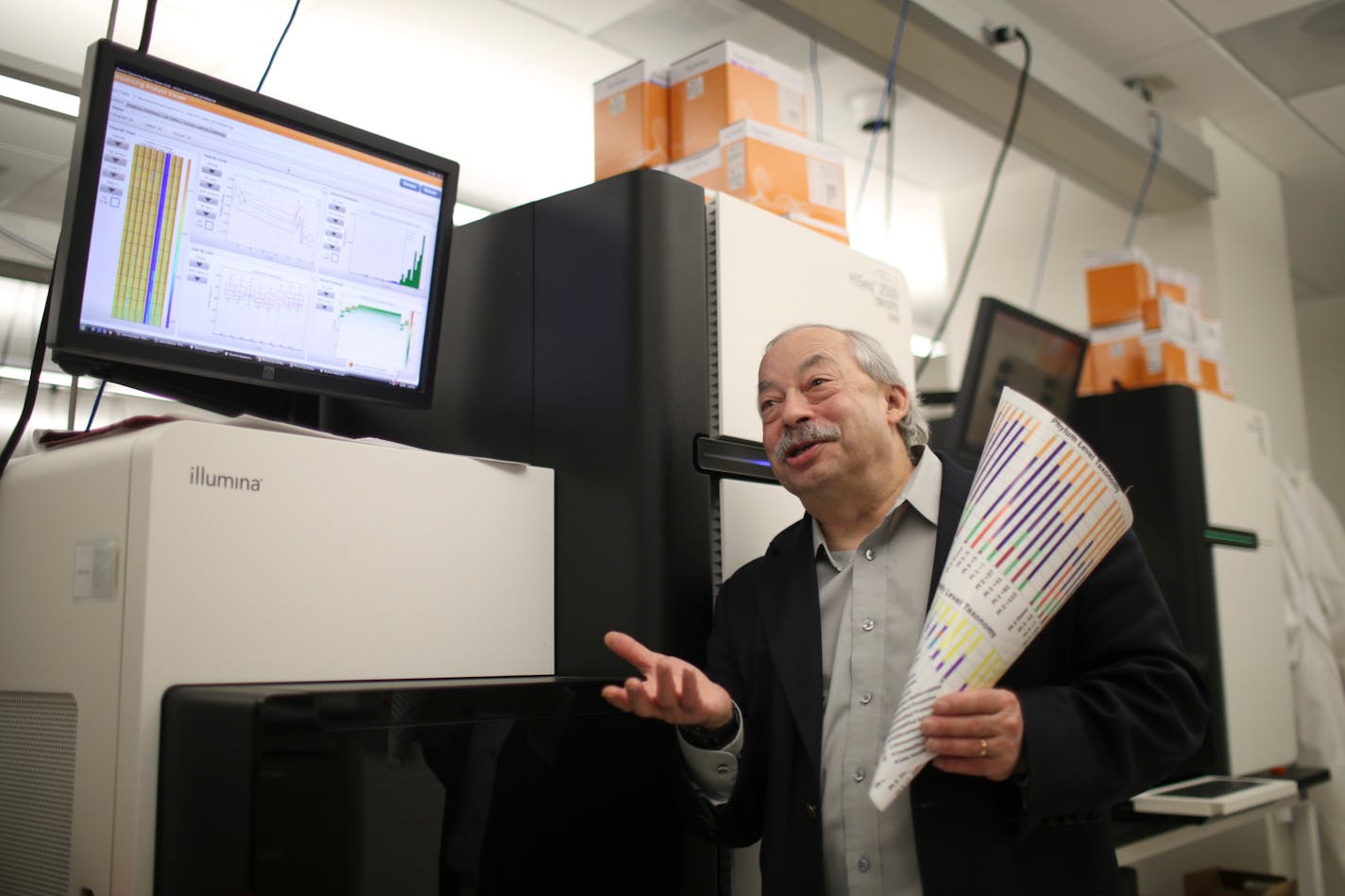 Michael Sadowsky, a microbiologist, was photographed with a with a genetic sequencing machine and a graphic representation of the genetic composition of gut microbiota at the Cancer & Cardiovascular Research Building on the U of M campus. ] JEFF WHEELER • jeff.wheeler@startribune.com.