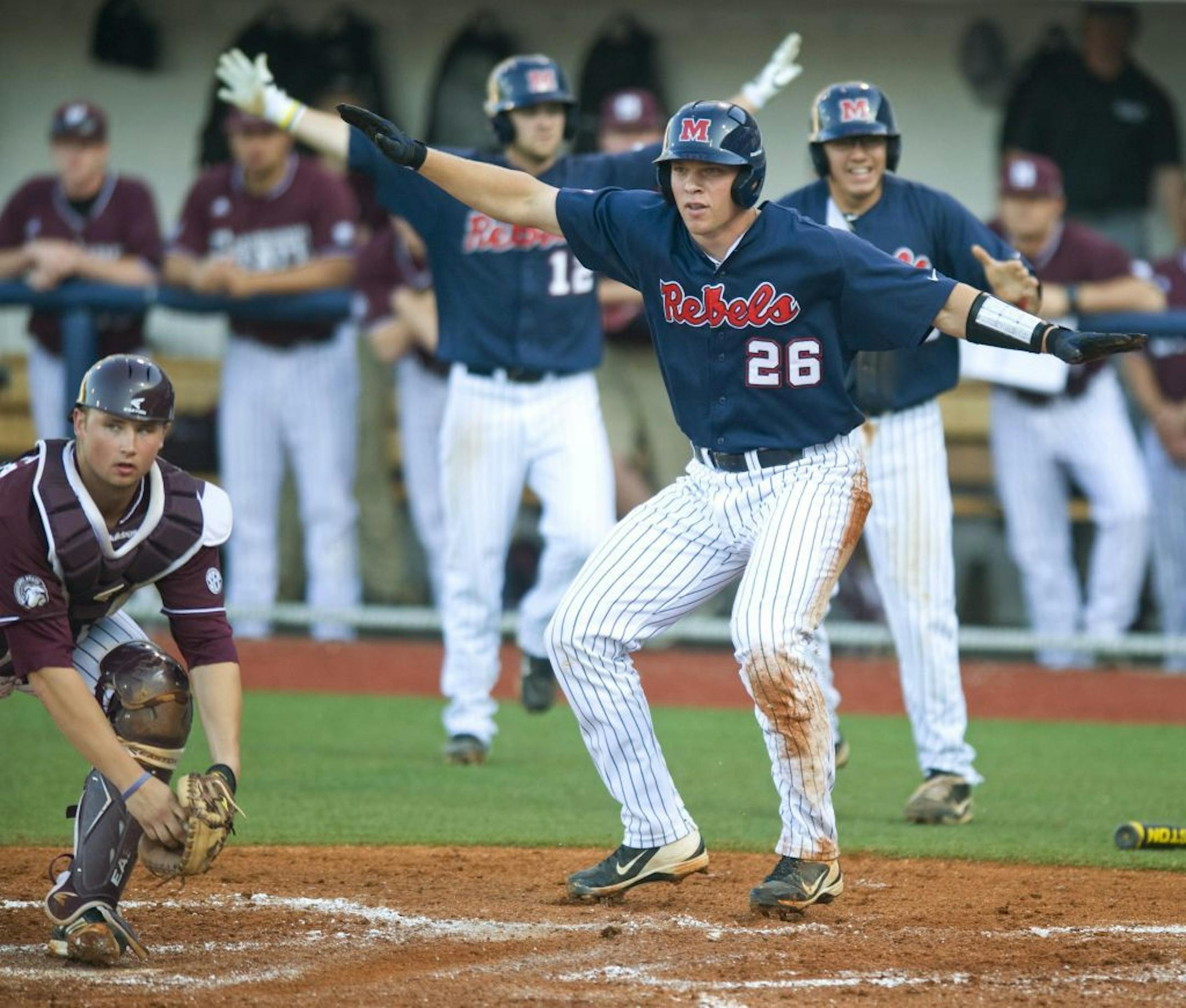 Mississippi's Stuart Turner (26) signals he is safe after Mississippi State catcher Mitch Slauter, left, tried to make the tag in Game 2 of a college baseball doubleheader in Oxford, Miss., on Saturday, May 11, 2013. (AP Photo/Oxford Eagle, Bruce Newman) MAGS OUT NO SALES MANDATORY CREDIT