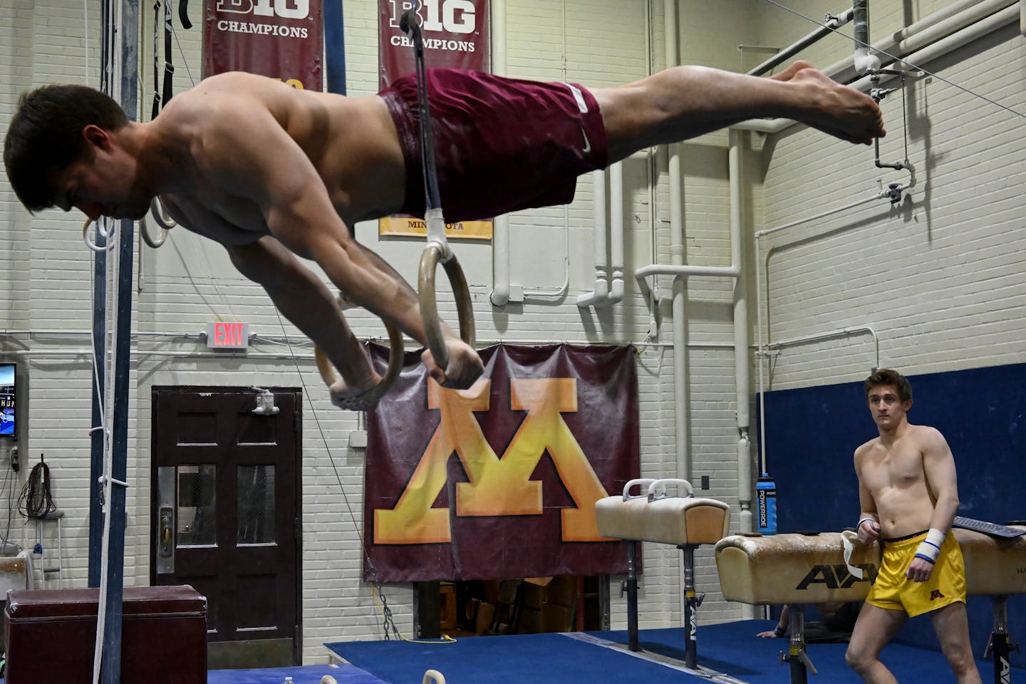 University of Minnesota Men's Gymnastics club's Yaroslav Owens-Pochinka practices on the rings as teammate Ben Hays watches Monday, April 25, 2022 at Cooke Hall in Minneapolis, Minn.. One season after the Gophers men's gymnastics team was cut, team members still compete for a club team in virtual meets, and the nationals start May 14. ] AARON LAVINSKY• Aaron.lavinsky@startribune.com