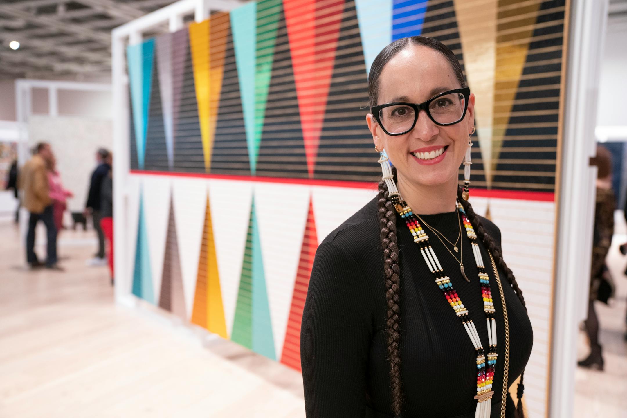 Dyani White Hawk poses in front of her work at the Whitney Museum of Art during its Biennial in New York, N.Y., on Wednesday, March 30, 2022. Barry Williams